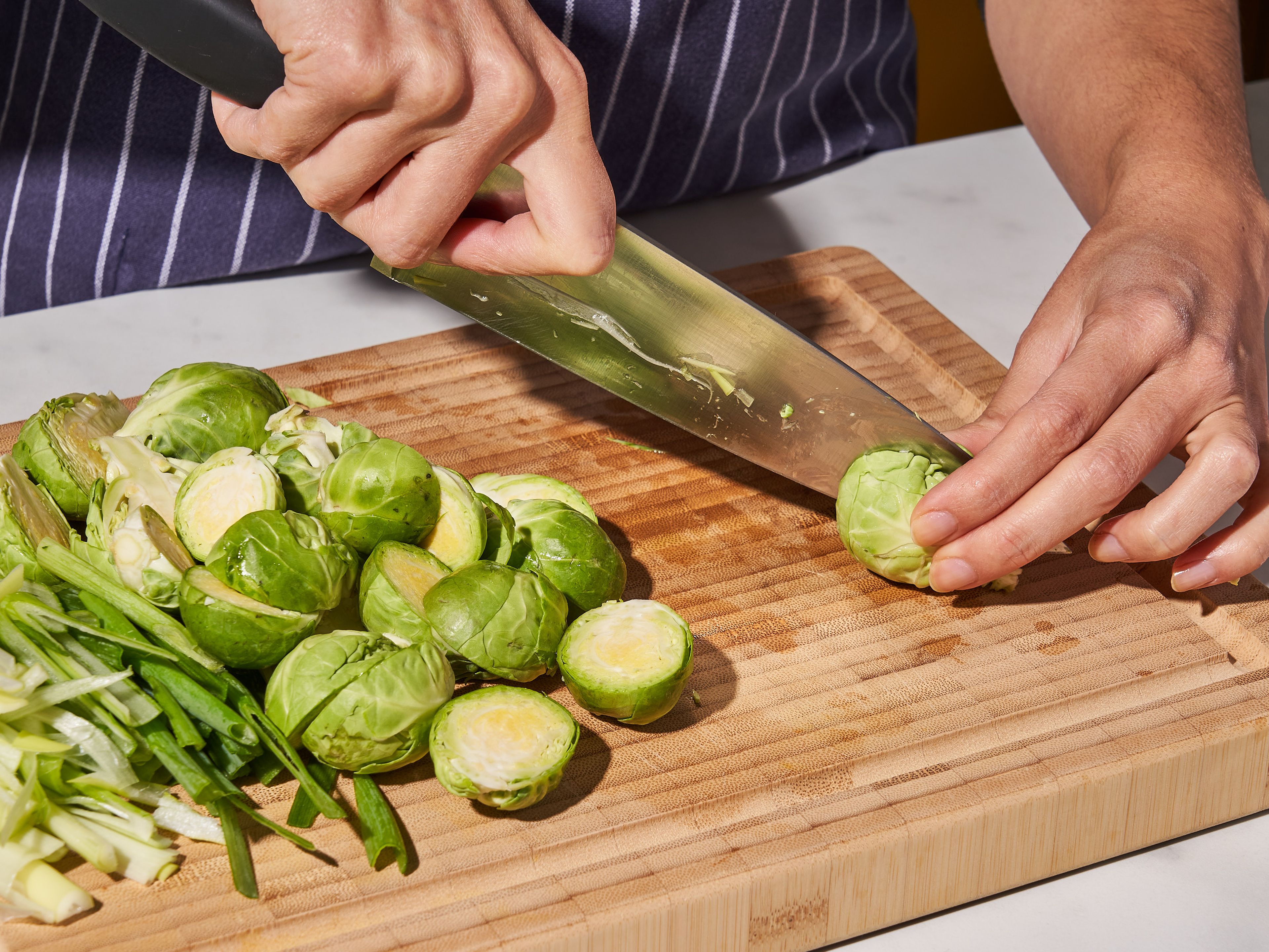 Slice scallions lengthwise and then chop into 1 in./3 cm strips. Set aside. Trim the ends and halve Brussels sprouts. Dissolve salt in the water. Submerge the Brussels sprouts in this brine and let sit for approx. 2 – 3 hrs. Add a weight, like a plate, on top so they are completely submerged. (If you have time, you can soak them overnight, too.) Rinse a few times under cold water and drain.