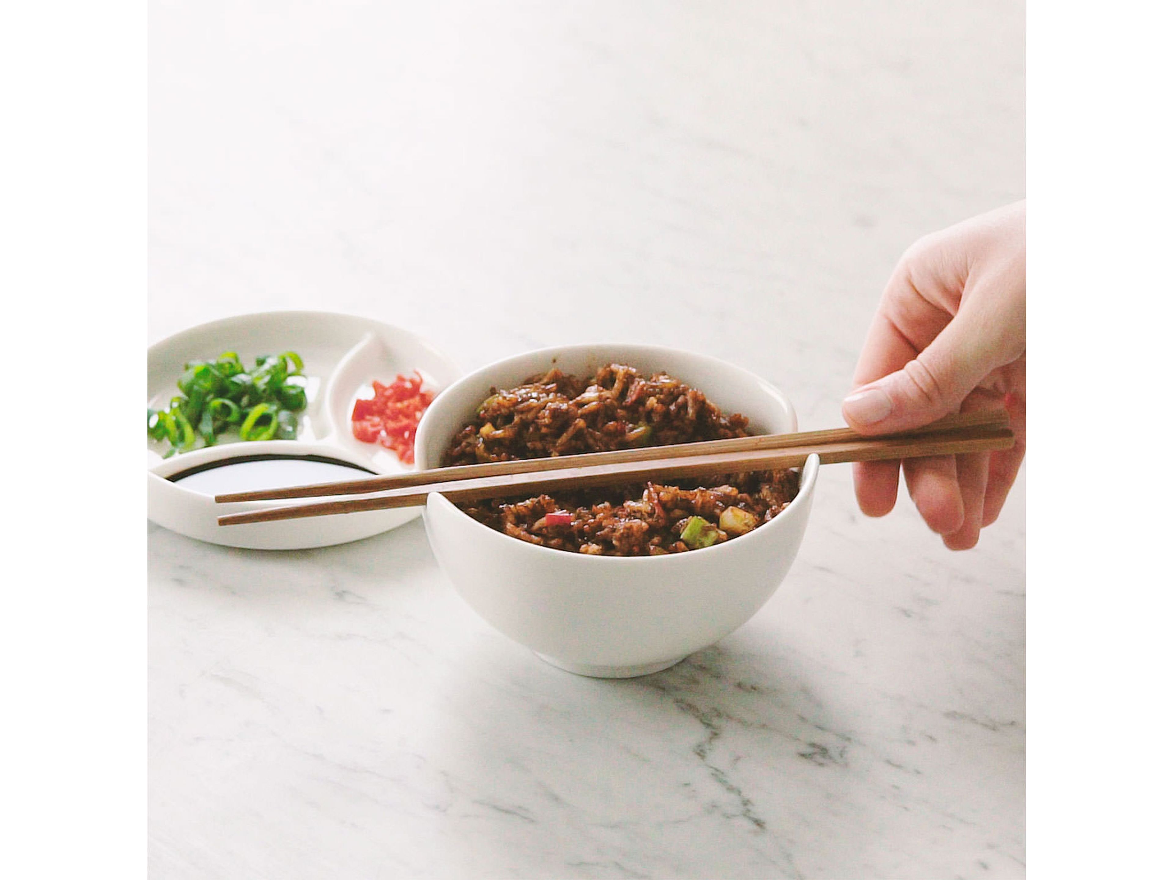 Transfer to a serving bowl and garnish with reserved scallion greens, fresh chili and soy sauce to taste. Enjoy!