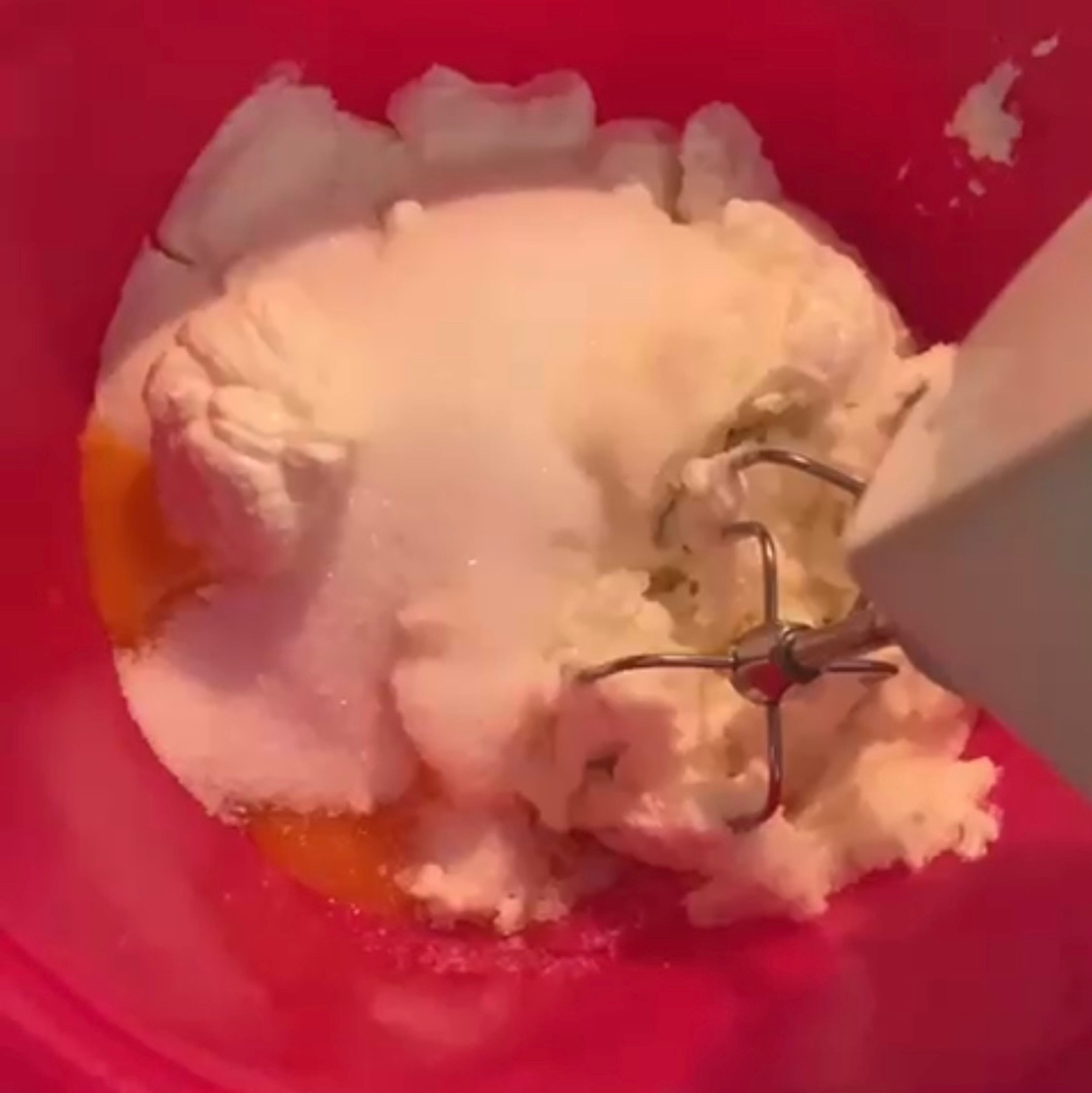 Den Zucker zum Quark und Eigelb geben und mit einem Handrührgerät vermischen