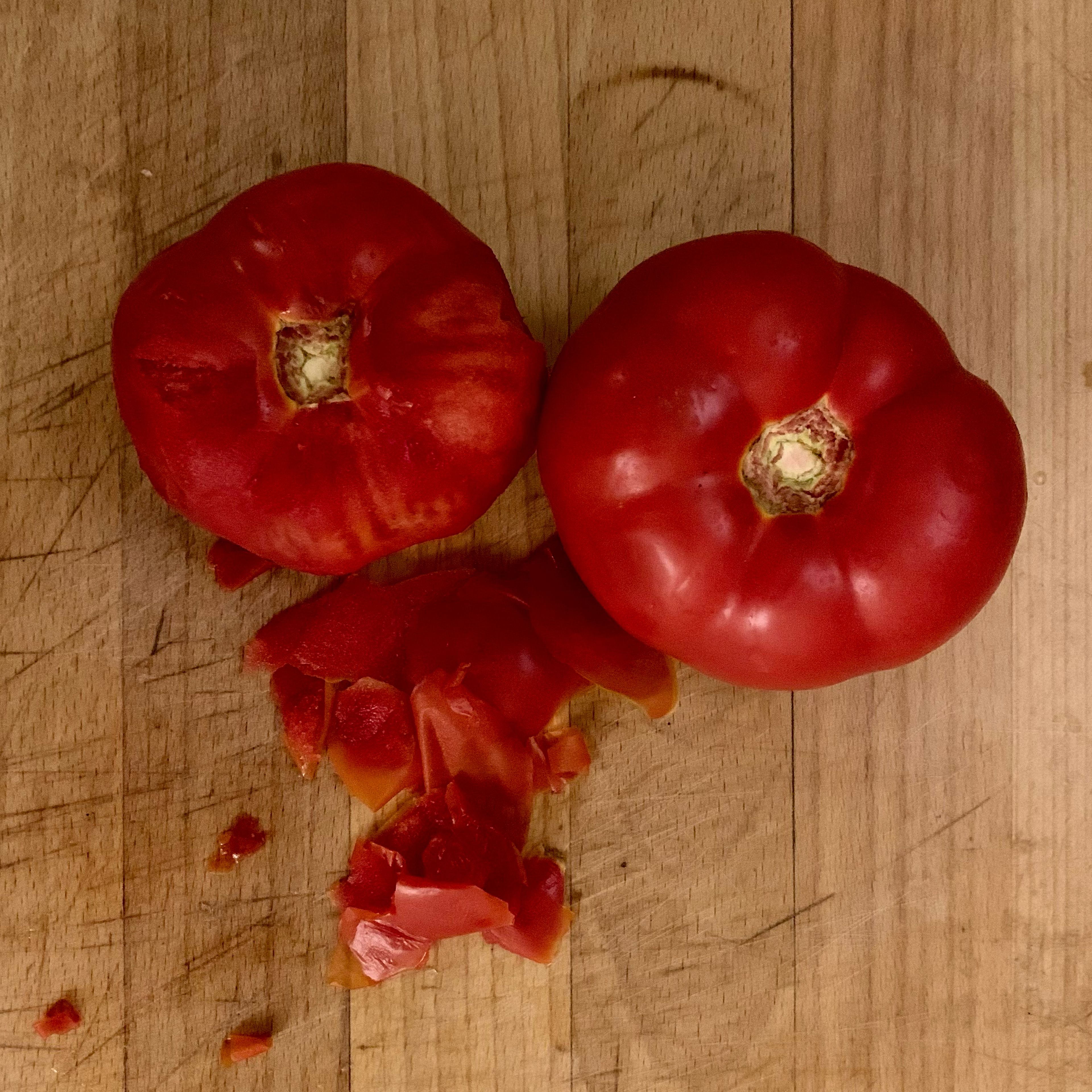 Während das Brot einweicht, schäle die Tomaten. Damit vermeidest du diese kleinen Schalenstücke nach dem Mixen. Wenn du wenig Zeit hast, kannst du diesen Schritt überspringen. Mixe dann einfach etwas gründlicher.