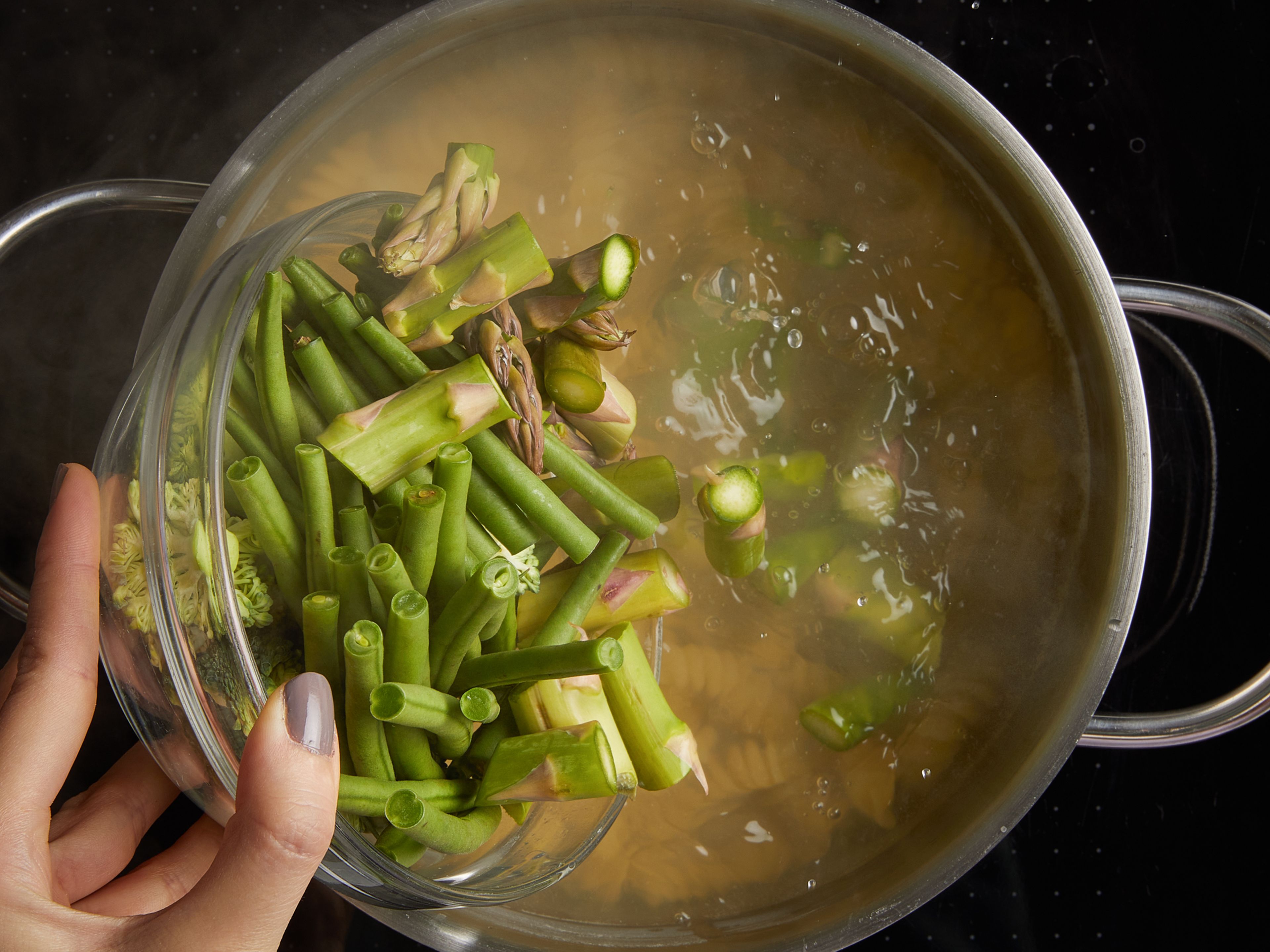 Approx. 5 min. before the pasta cooking time is up, add green beans and asparagus to the pot. Let cook for approx. 3 min., then add broccoli florets. Drain the pasta and vegetables, reserving some of the pasta water in a small bowl or mug.