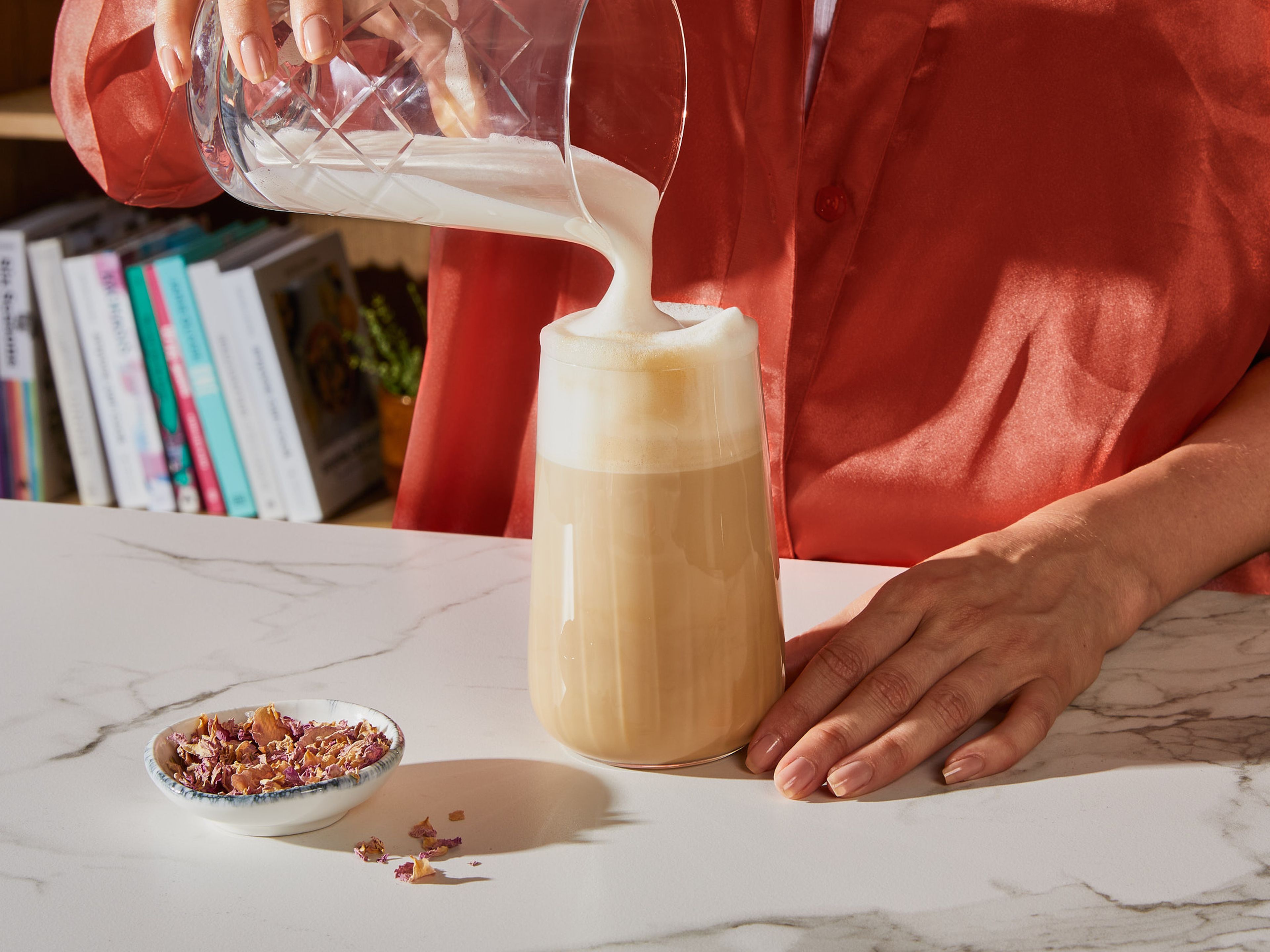 Zuletzt langsam den aromatisierten Schaum über den Espresso gießen. Mit Rosenblättern garnieren.