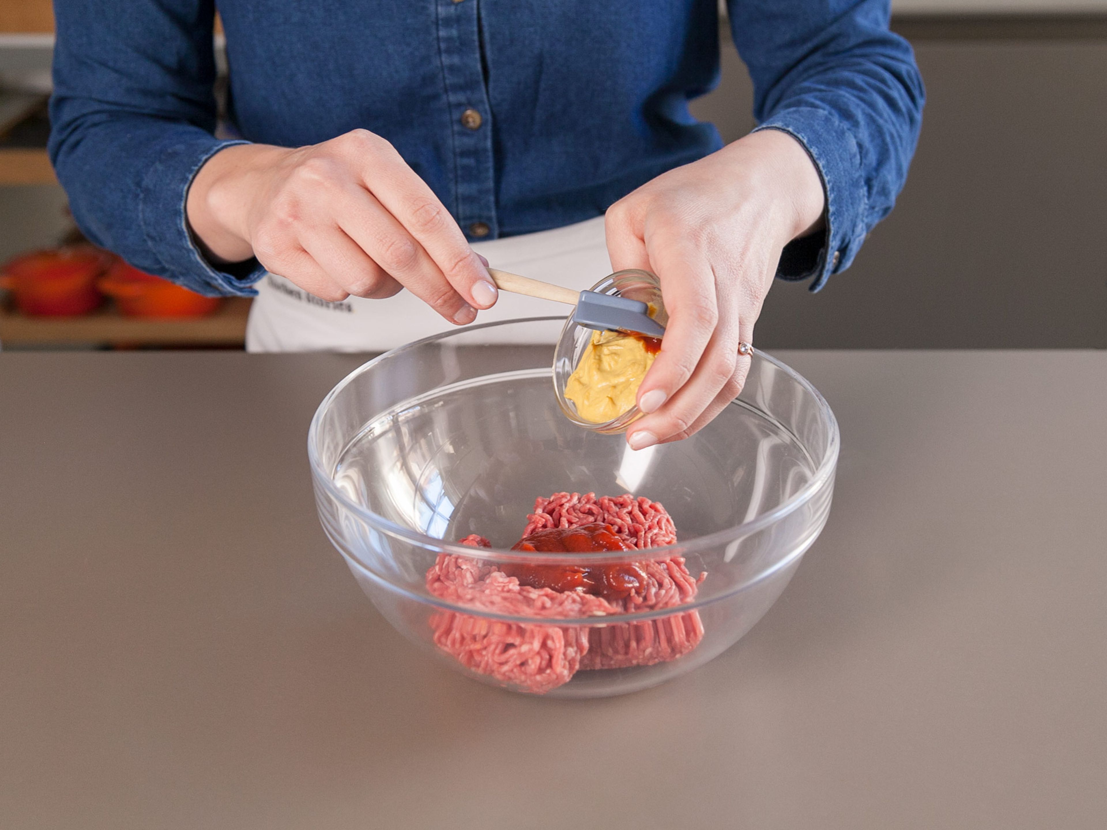 Add ground beef, Dijon mustard, and ketchup to a mixing bowl. Season with salt and pepper and mix together until combined. Divide in half and form two burger patties with your hands.