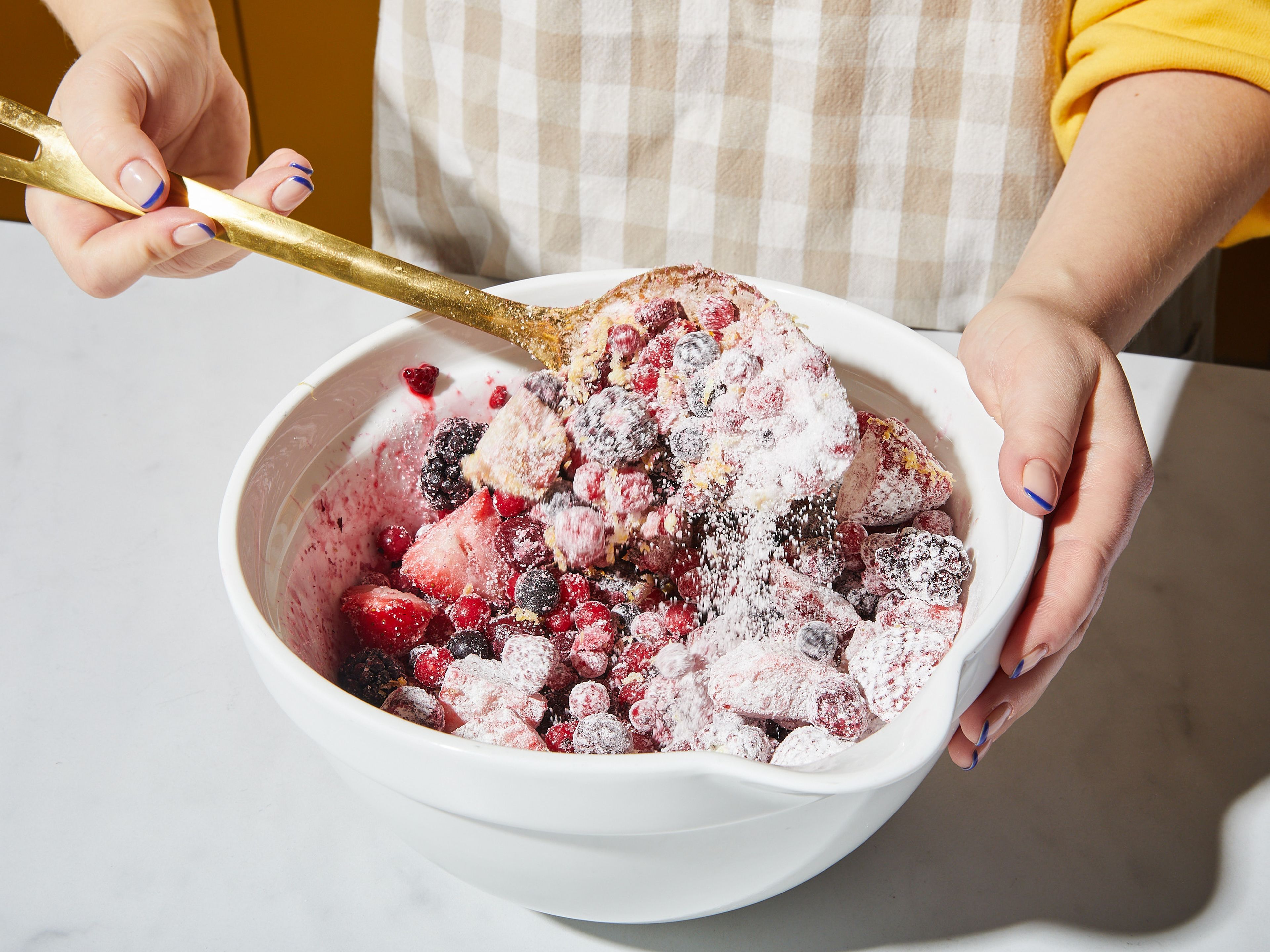 Preheat the oven to 190°C/375°F top/bottom heat. Toss frozen berries in a large bowl with sugar, starch, salt, and vanilla bean paste. Zest lemon over the mixture and toss once more. Mix raw sugar with cardamom and set aside. Crack egg into a small bowl, whisk, and set aside.