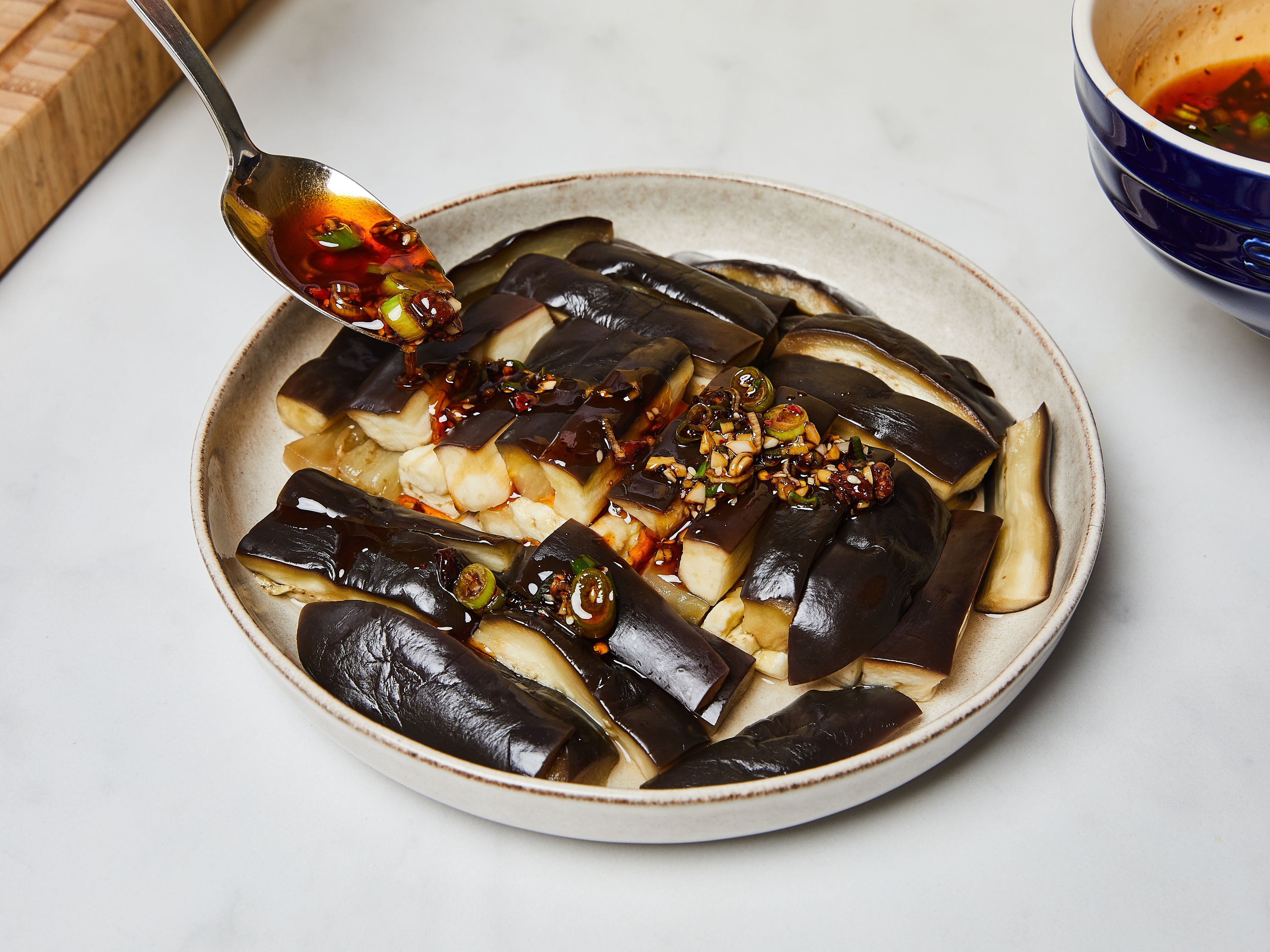 When the eggplant is ready, remove from the steamer basket. Arrange on the serving plate and pour over the sauce. Serve the dish warm, room-temperature or cold, with steamed rice.