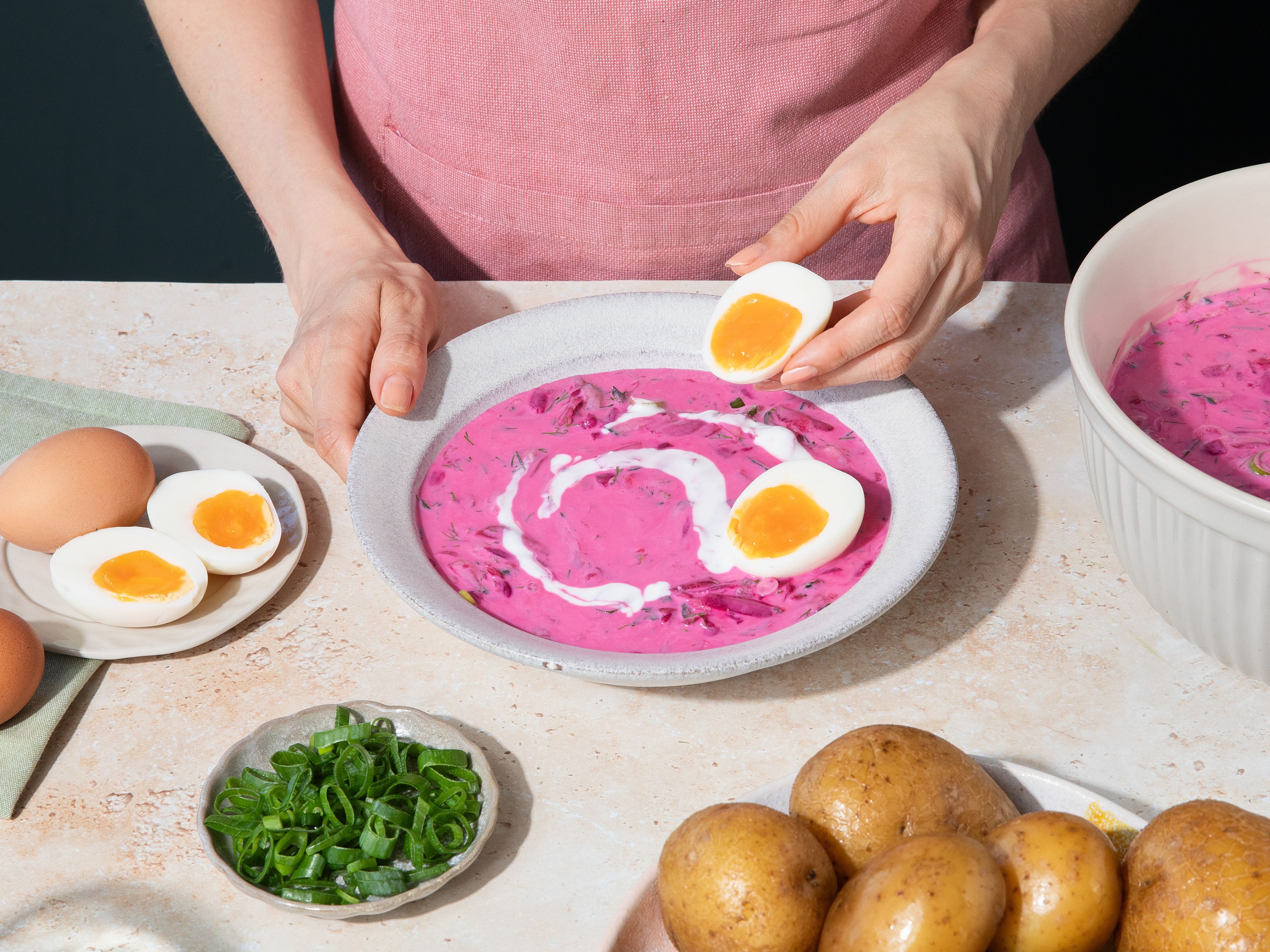 Während die Suppe kühlt, Kartoffeln in Salzwasser gar kochen. Die Eier ca. 7–9 Min. wachsweich oder hart kochen, abschrecken, schälen und halbieren. Die kalte Suppe nach Belieben noch einmal nachwürzen und mit Kartoffeln, Eiern, Frühlingszwiebeln und Dill und nach Belieben zusätzlichem Kefir servieren.