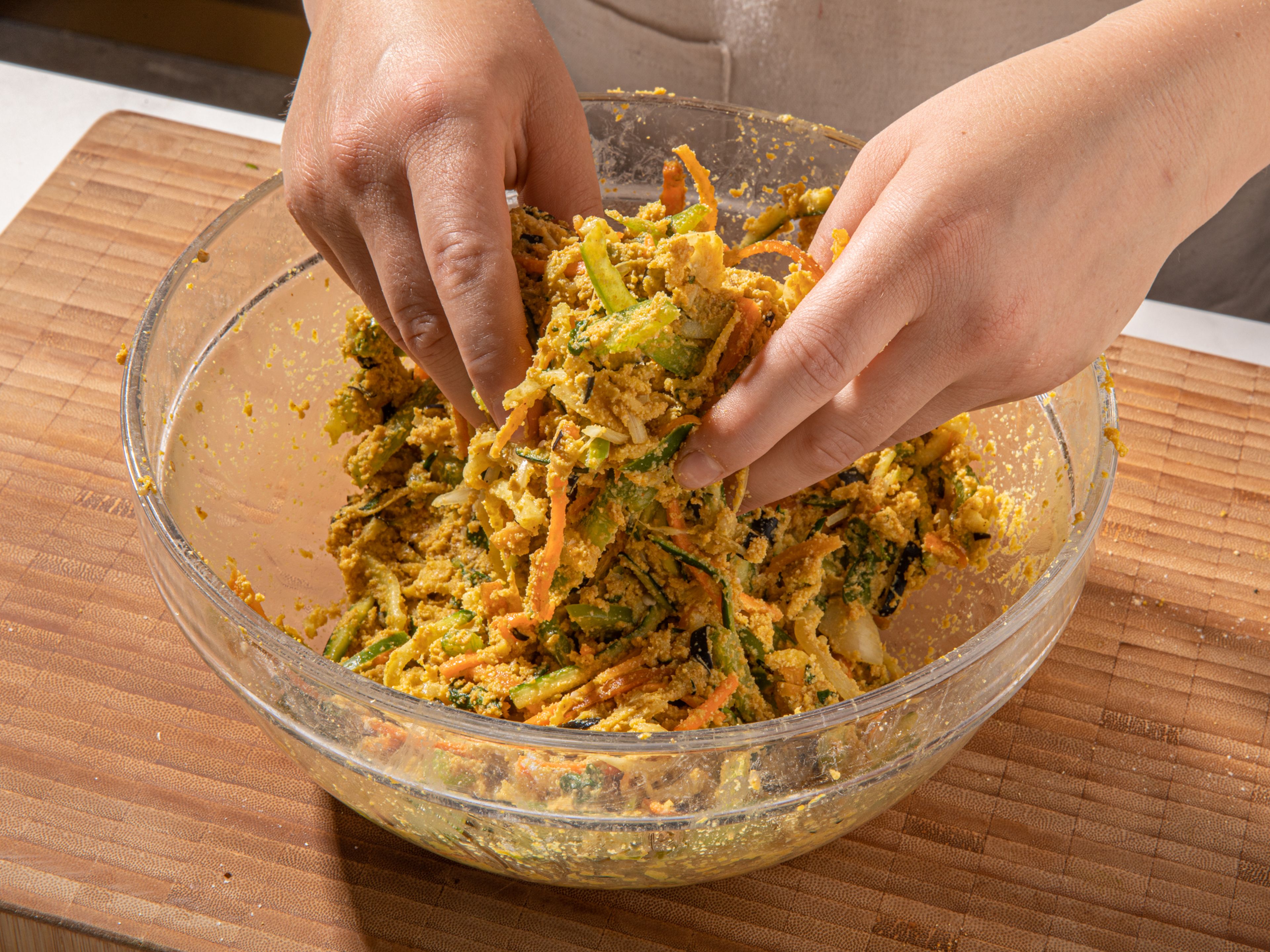 Use your hands to mix the vegetable mixture together and squeeze out some moisture. Let sit for 5 minutes, to extract the moisture out. Add rice flour, and if needed, a little water to form a batter that sticks together, but isn’t runny.