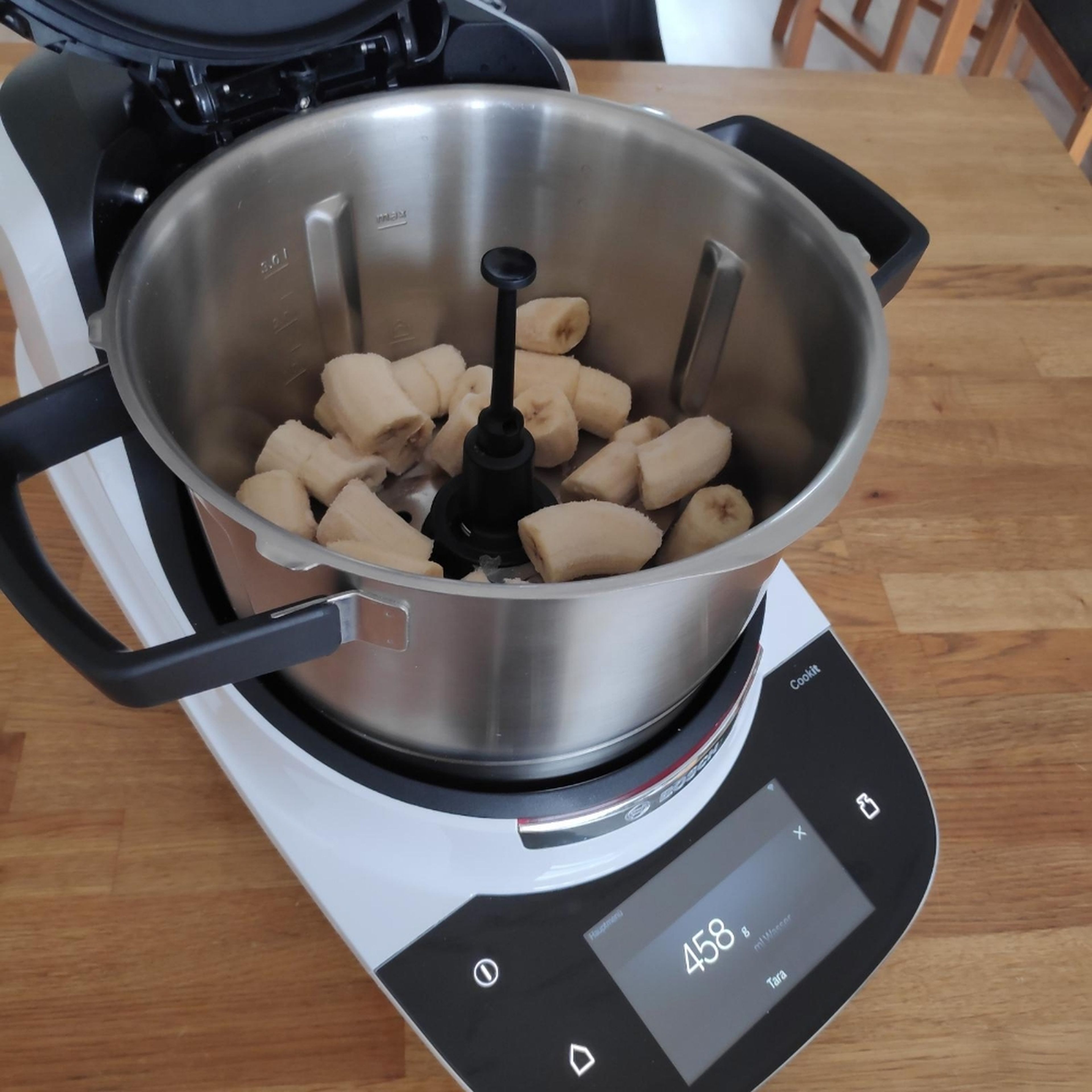 Die gefrorenen Bananen in den Topf des Cookit geben, den Deckel schließen, den Messerbecher einsetzen und zerkleinern, bis eine cremige Konsistenz entsteht (Universalmesser I Stufe 18 I 40 Sekunden).