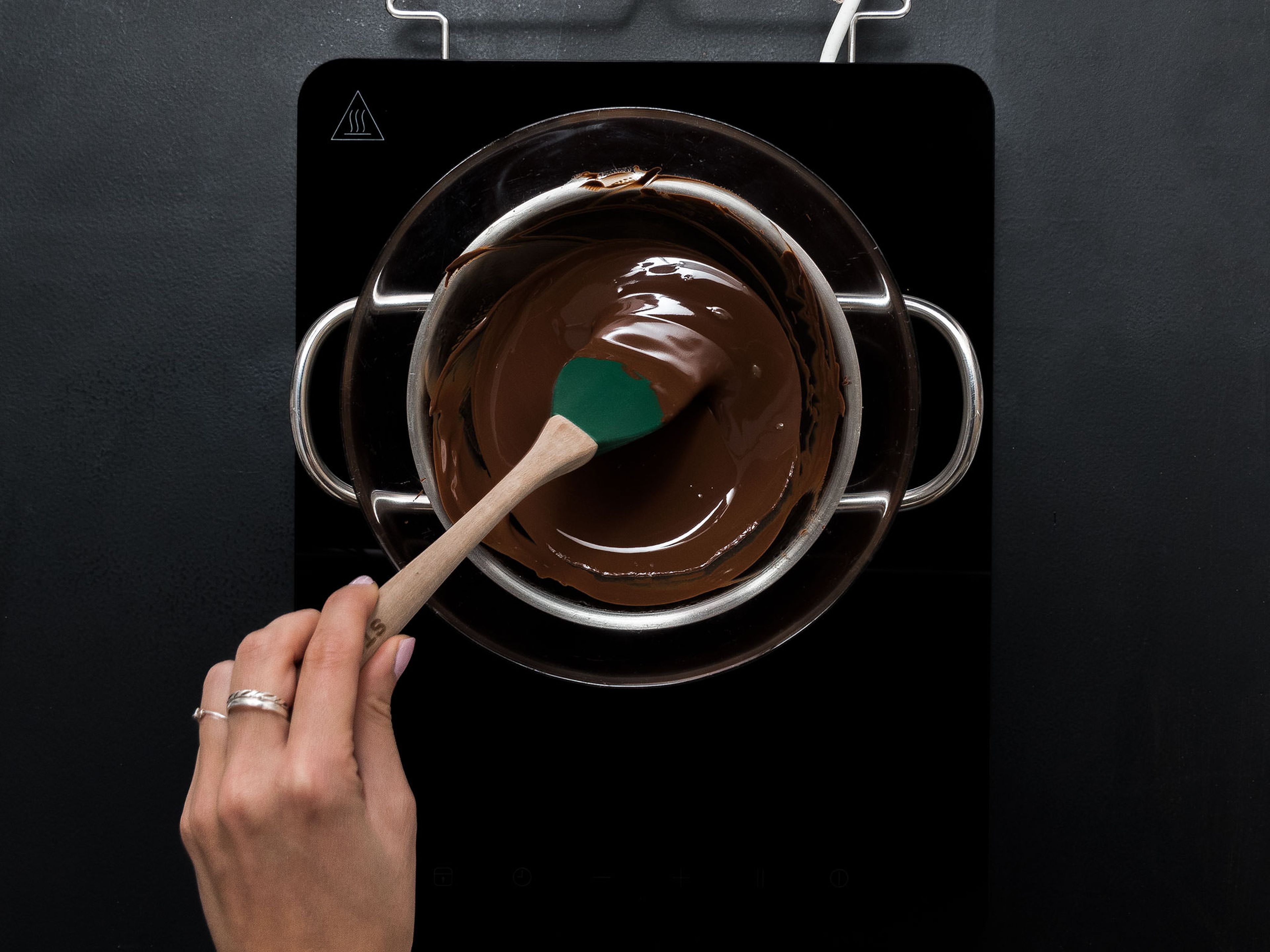 Schokolade hacken oder in Stücke brechen und über einem Wasserbad schmelzen. Dabei vorsichtig umrühren, bis die Schokolade geschmolzen ist.