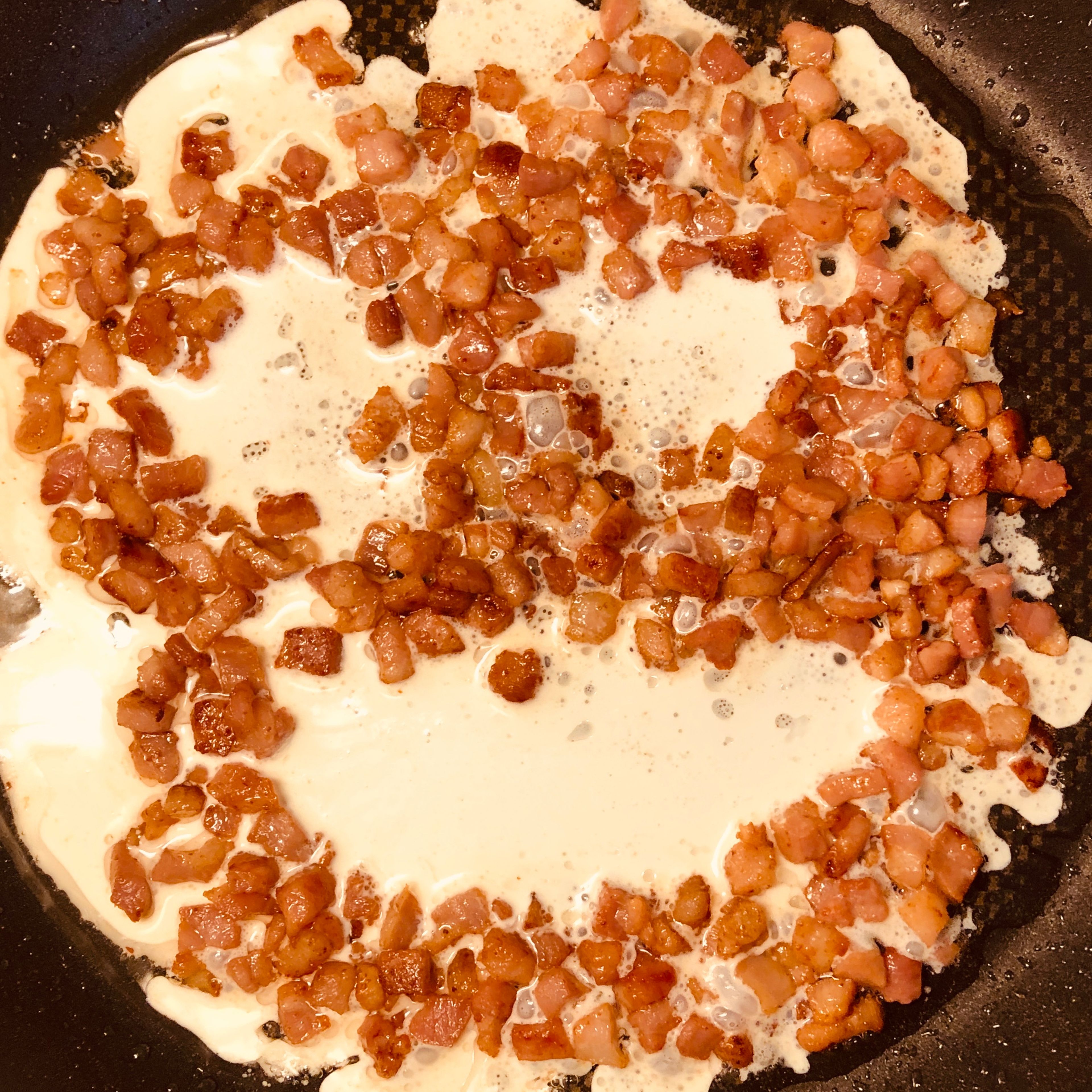 Fry the bacon. Add the cream before the bacon parts get too burned. Add the cheese to the sause gradually. Let the sause sipper, add more cheese to control the consistency. Add pepper to the sause. Cook the spaghetti, add very little salt.