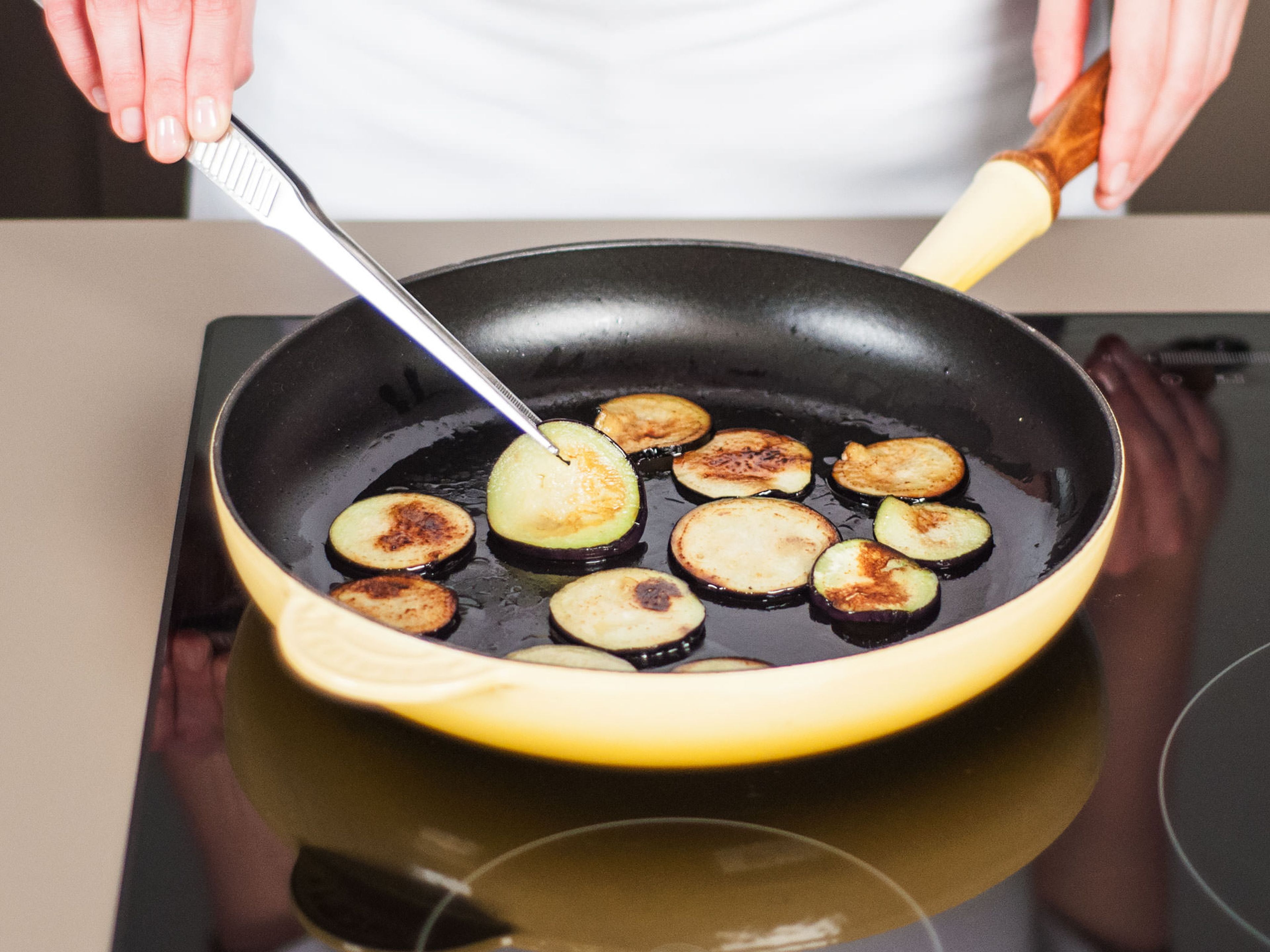 Heat some vegetable oil in a pan. Fry eggplant slices over medium heat on each side for approx. 3 – 5 min. until lightly roasted and soft. Season with salt and pepper. Remove from pan and set aside.