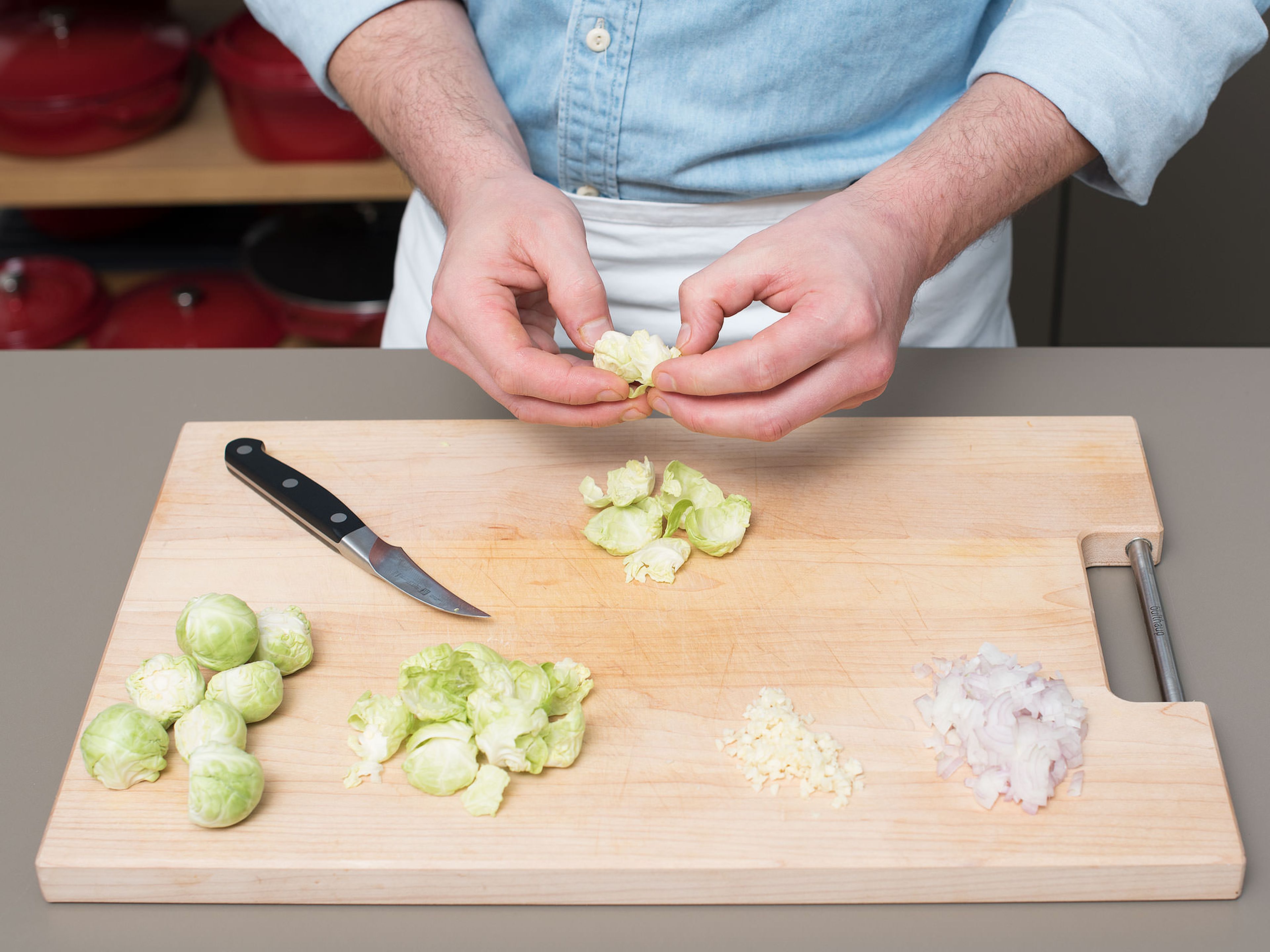 Peel and mince shallots and garlic. Clean and peel Brussels sprouts, then remove the stalk and separate the leaves.