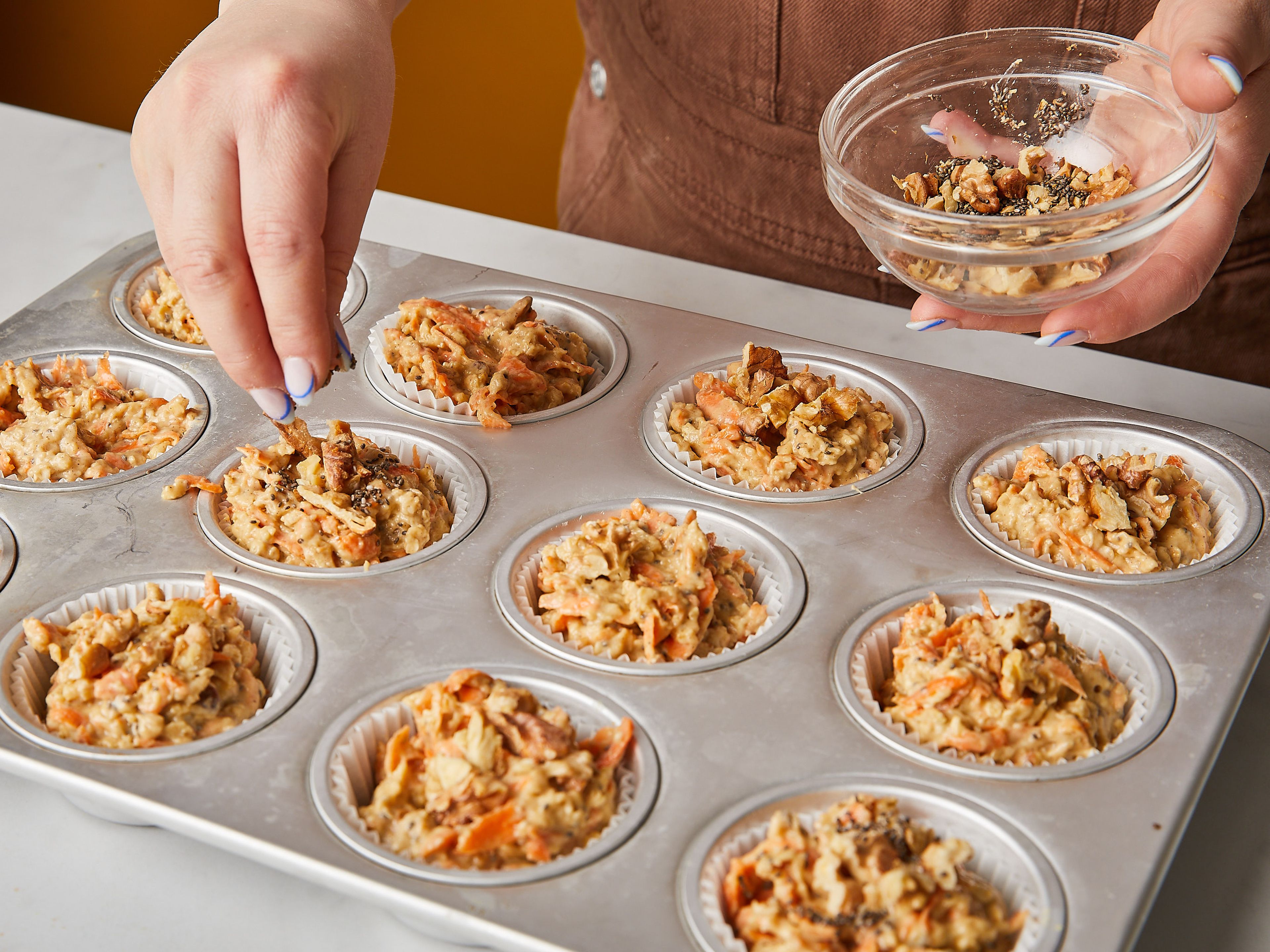 Line a muffin tin with liners. Use a large spoon or scoop to fill each liner to the brim. Top with remaining walnuts, and bake at 175°C/350°F for approx. 25 – 27 min. Remove muffins from the oven and let cool for approx. 5 mins., then remove muffins from the tin. Let cool completely before storing in an airtight container. Enjoy!