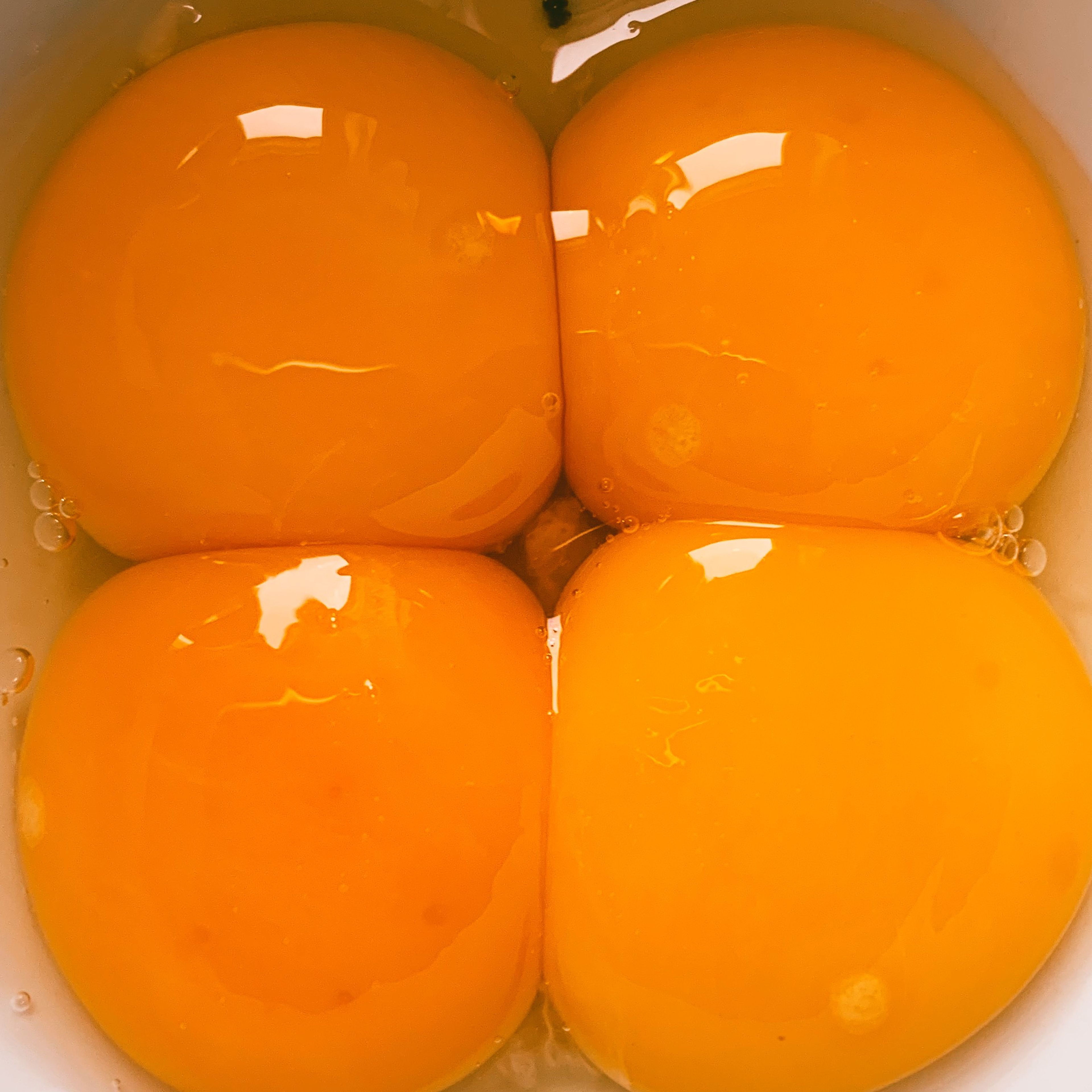 Den Pecorino (falls noch nicht geschehen) reiben. Die Eier trennen und je zwei Eigelb auf zwei tiefe Teller verteilen.