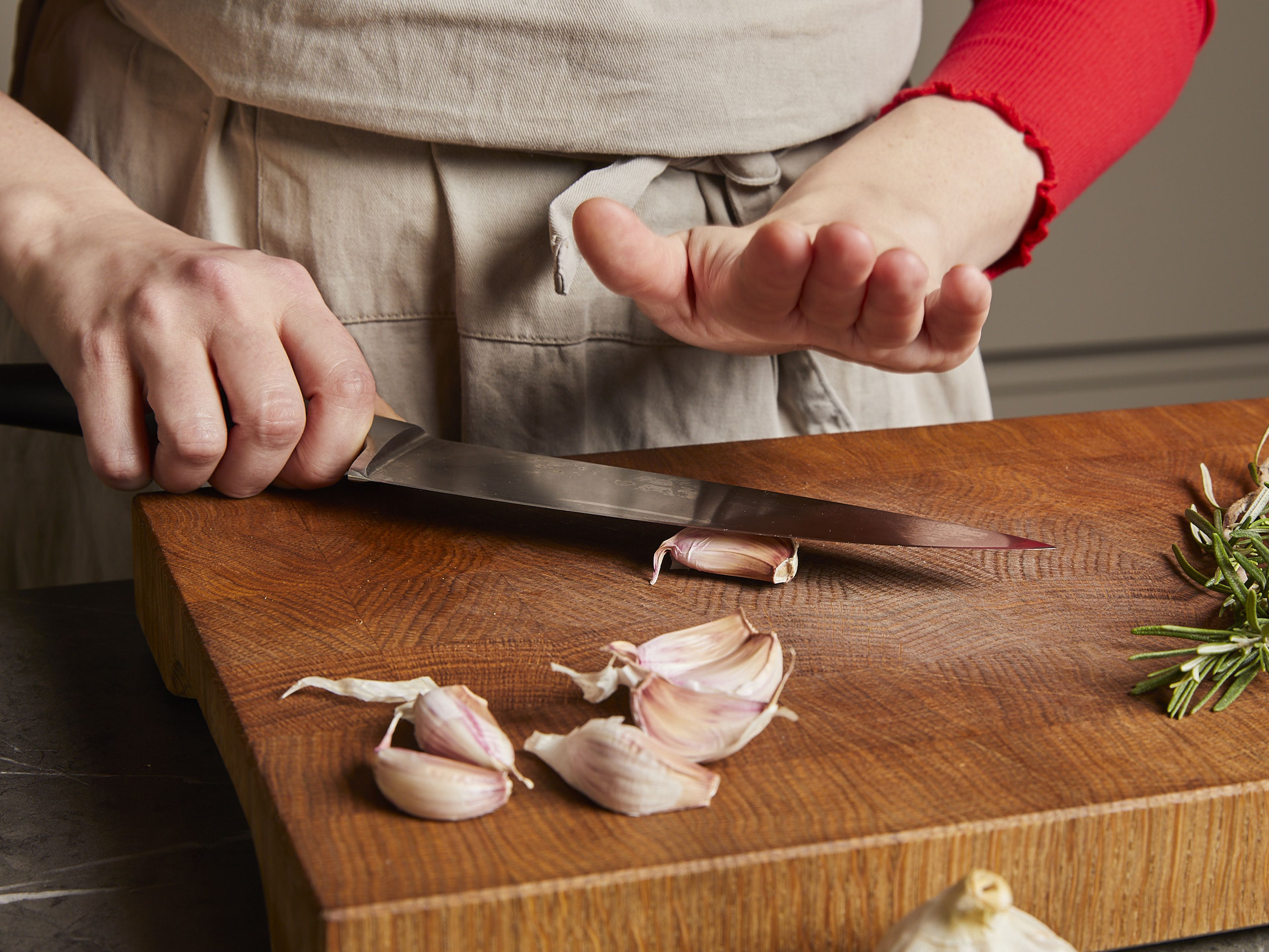 Für das Steak den Backofen auf 90°C vorheizen. Knoblauchzehen mit einem Messer vorsichtig andrücken und schälen.