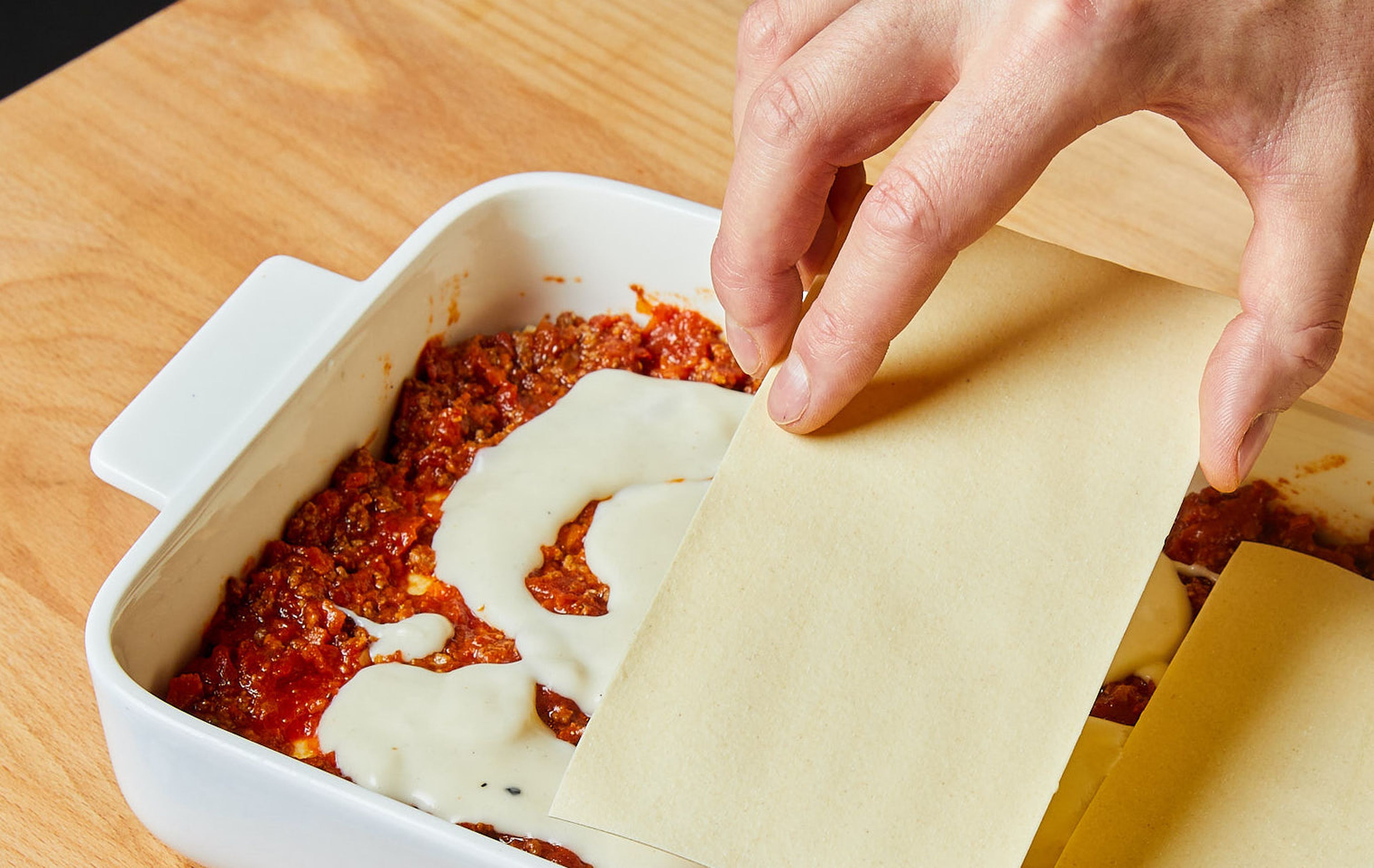Cover the base of an air fryer mold with olive oil and then with a layer of béchamel. Now layer the lasagna sheets first, then the Bolognese and béchamel sauce in succession. Repeat until all the ingredients have been used up, finishing with béchamel on top.