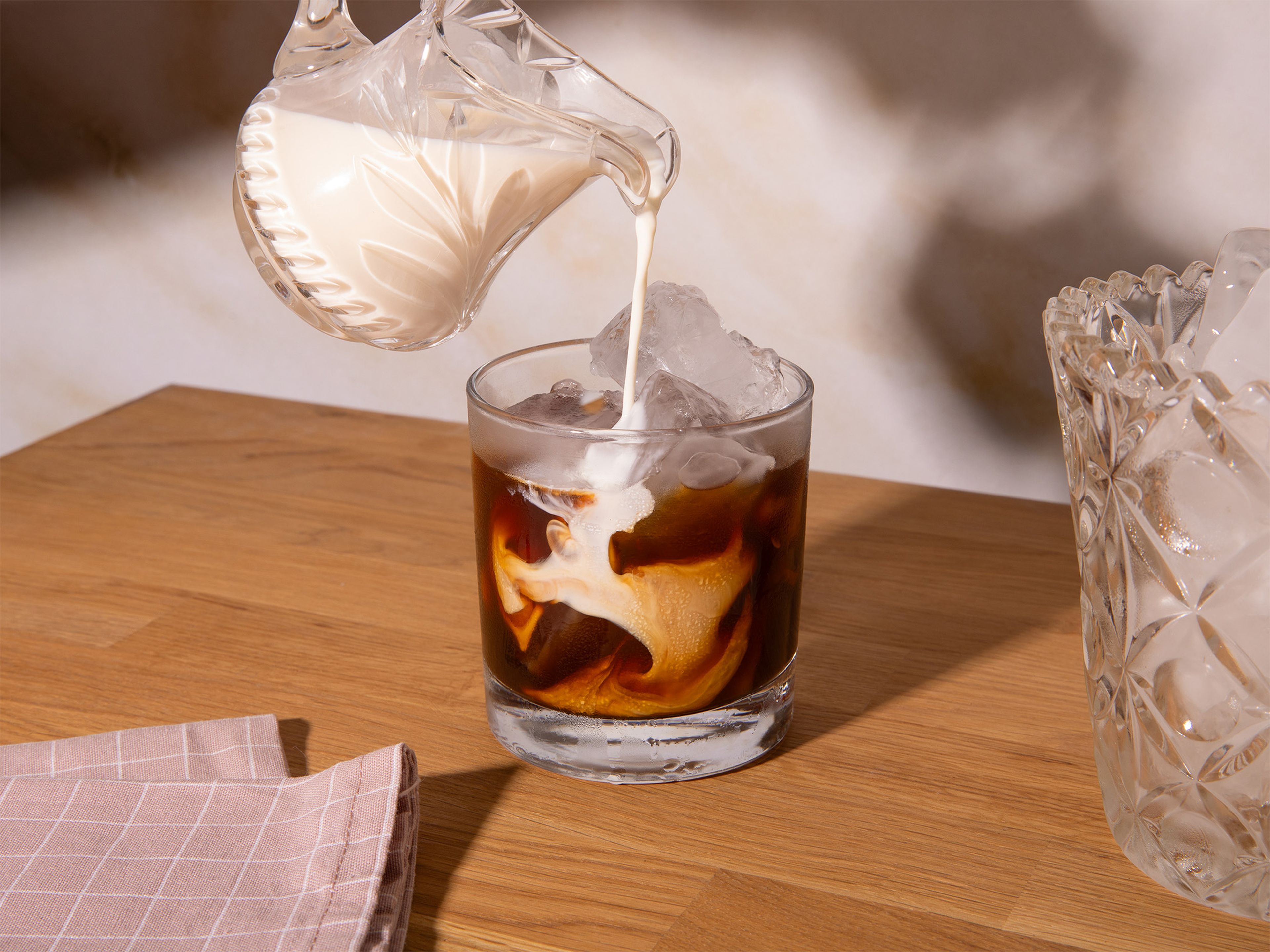 Zwei Gläser mit Eiswürfeln füllen. Den abgekühlten Espresso über das Eis geben. Die Mandelmilch langsam in beide Gläser füllen.