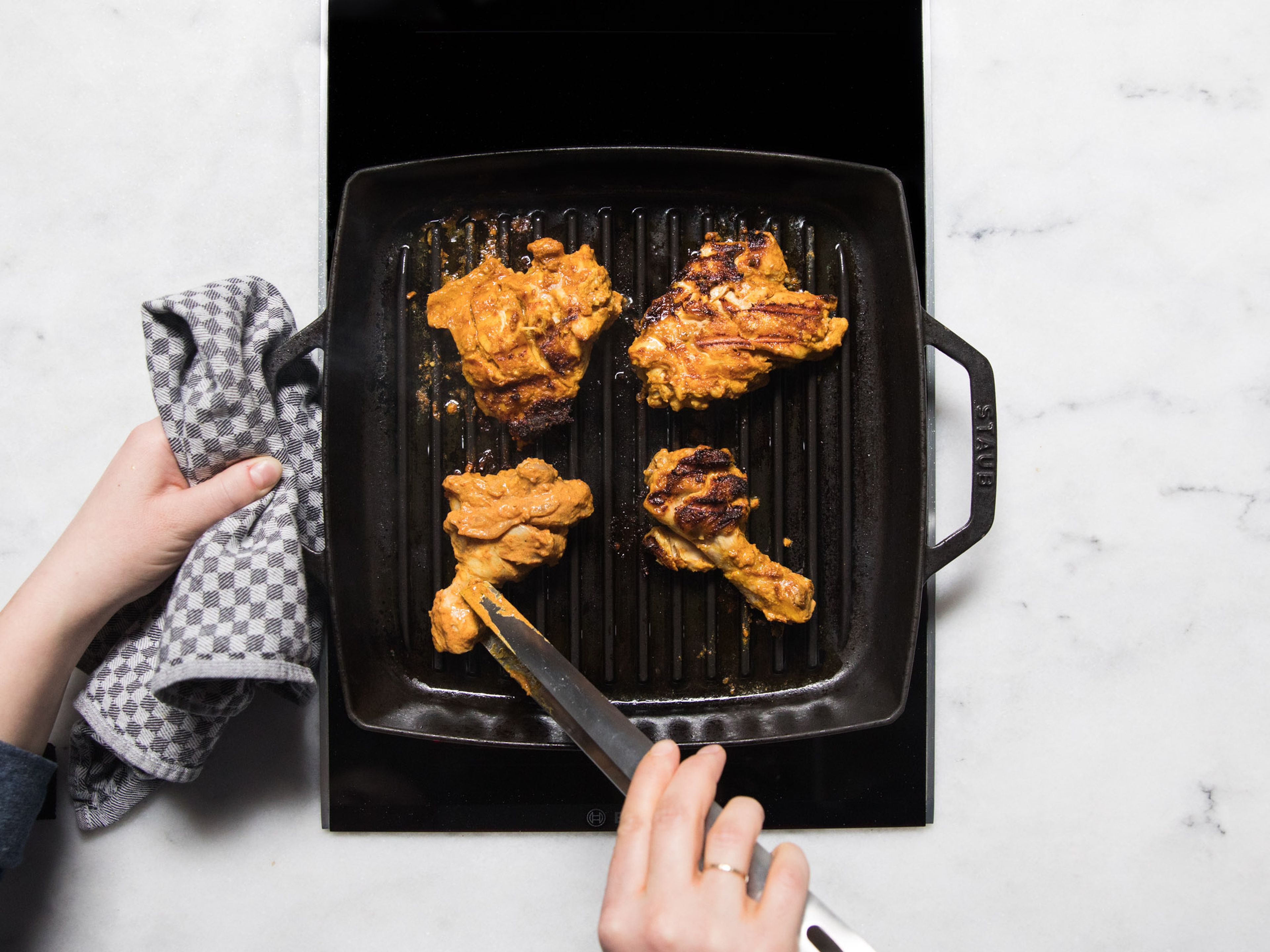 Remove chicken from the fridge and allow to warm up to room temperature. Heat ghee in a grill pan and fry chicken for 6 – 7 min. on each side, until lightly charred and cooked through. Serve with naan bread and raita. Enjoy!