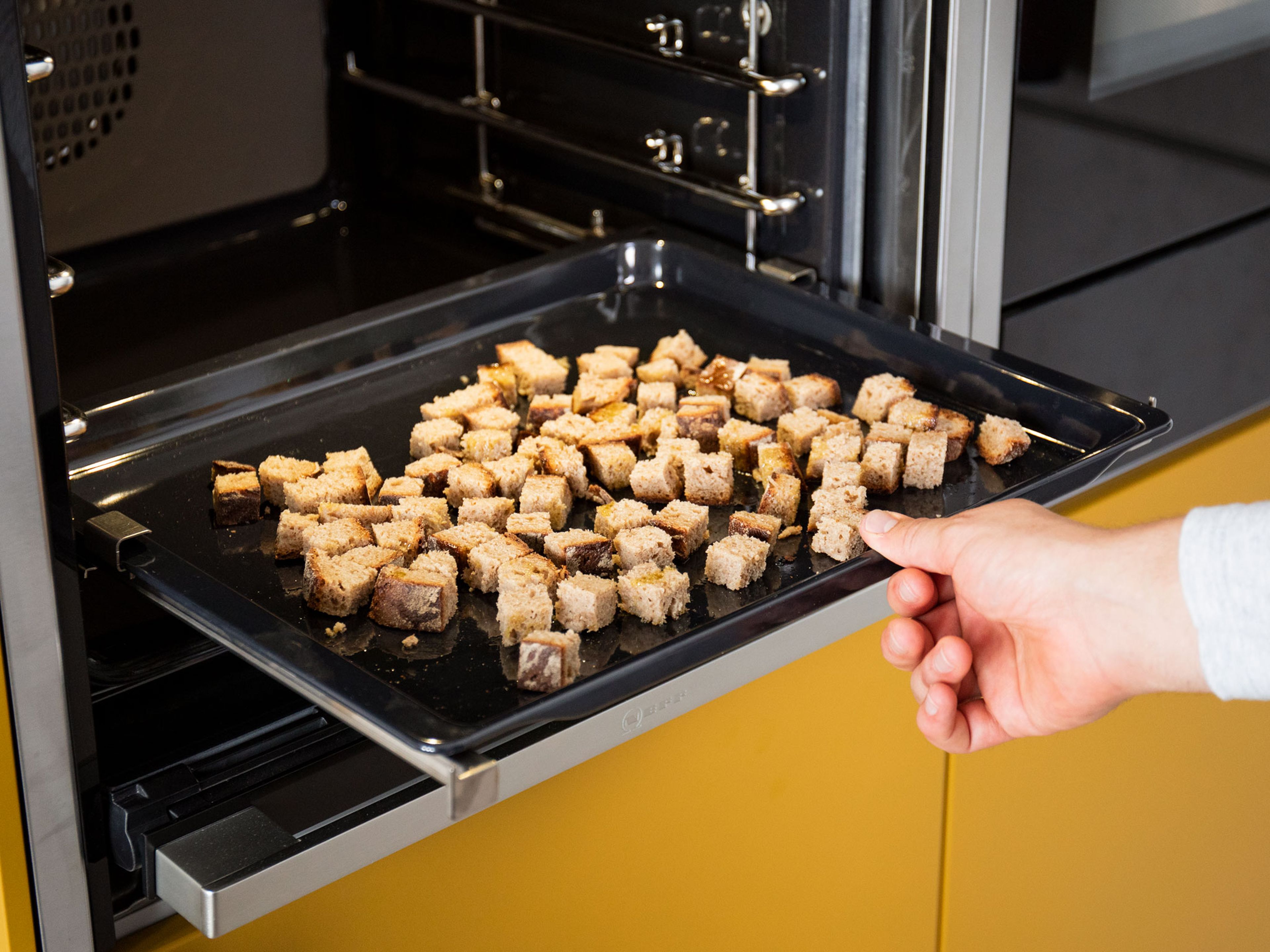 Preheat oven to 160°C/320°F. To make the croutons, cut bread into small cubes and transfer to a parchment-lined baking sheet. Toss with olive oil and bake for approx. 15 – 20 min.