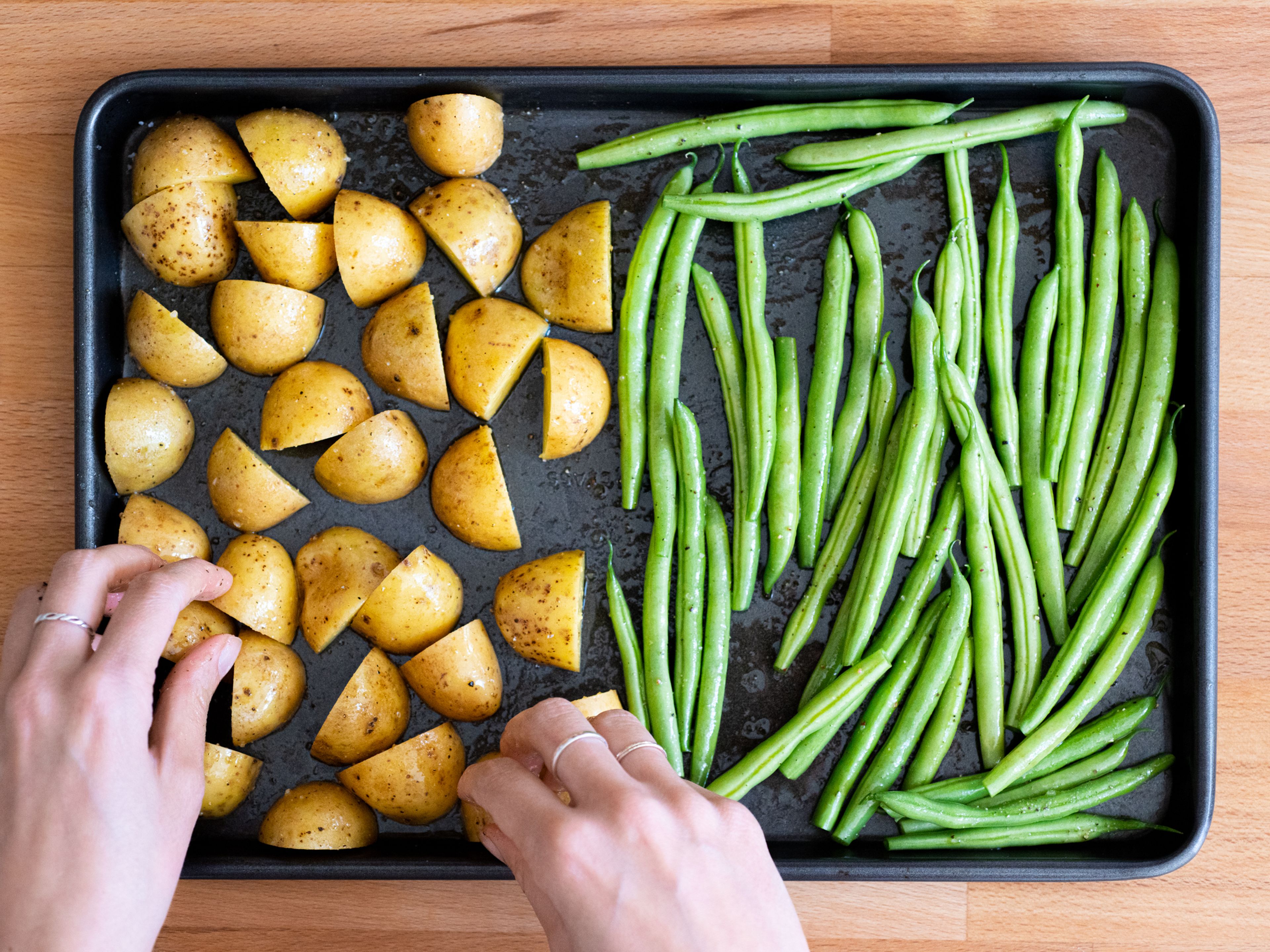 Add green beans and potatoes to a baking sheet. Drizzle with olive oil and season with salt and pepper. Toss to combine, then transfer to the oven and let roast for approx. 20 min., or until green beans are charred and potatoes are a bit browned and crisp on the bottom.