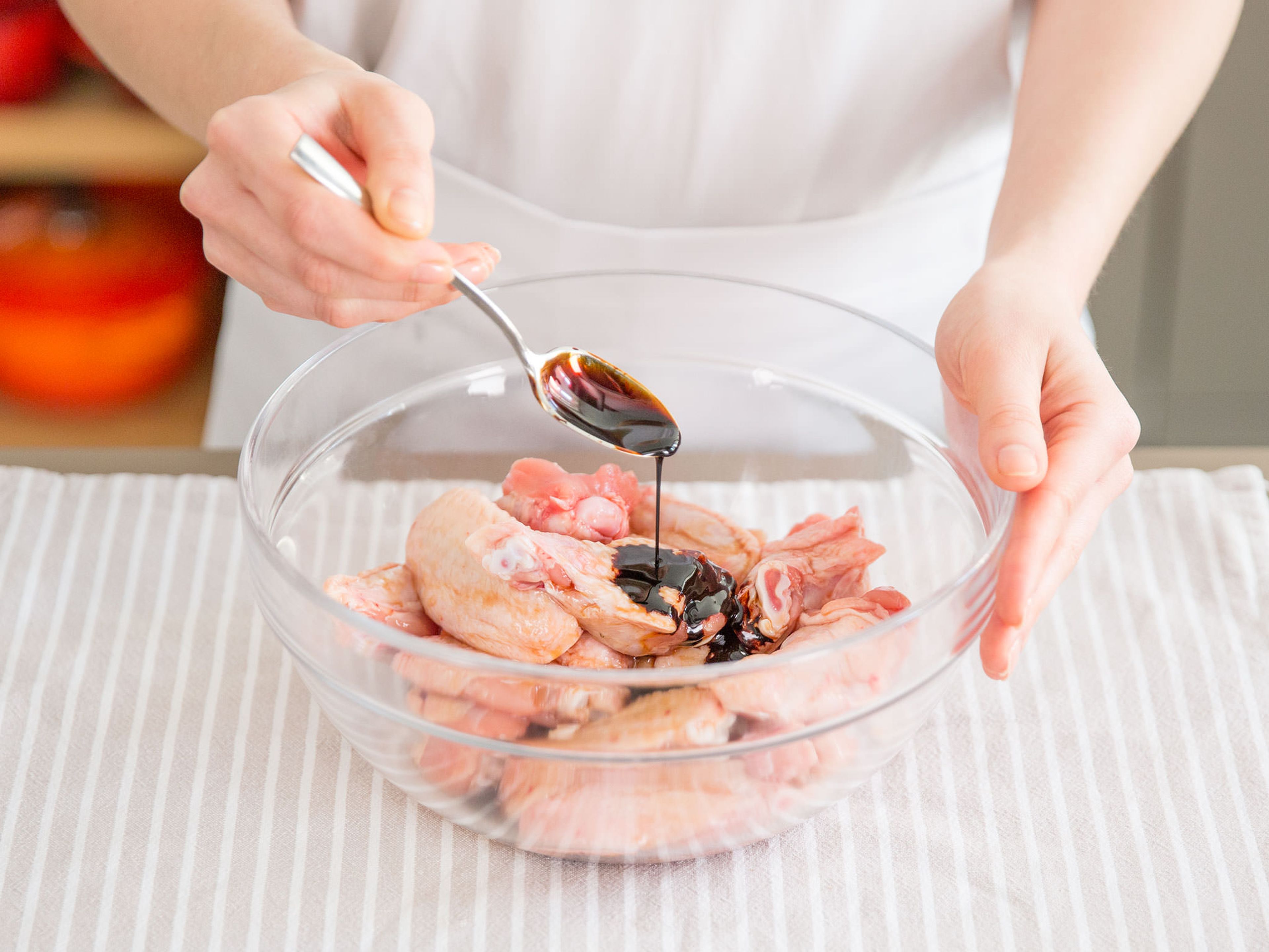 Hähnchenflügel mit Salz, Hälfte des Kochweins und Hälfte der dickflüssigen und dünnflüssigen Sojasoße in einer großen Schüssel ca. 10 Min. marinieren.