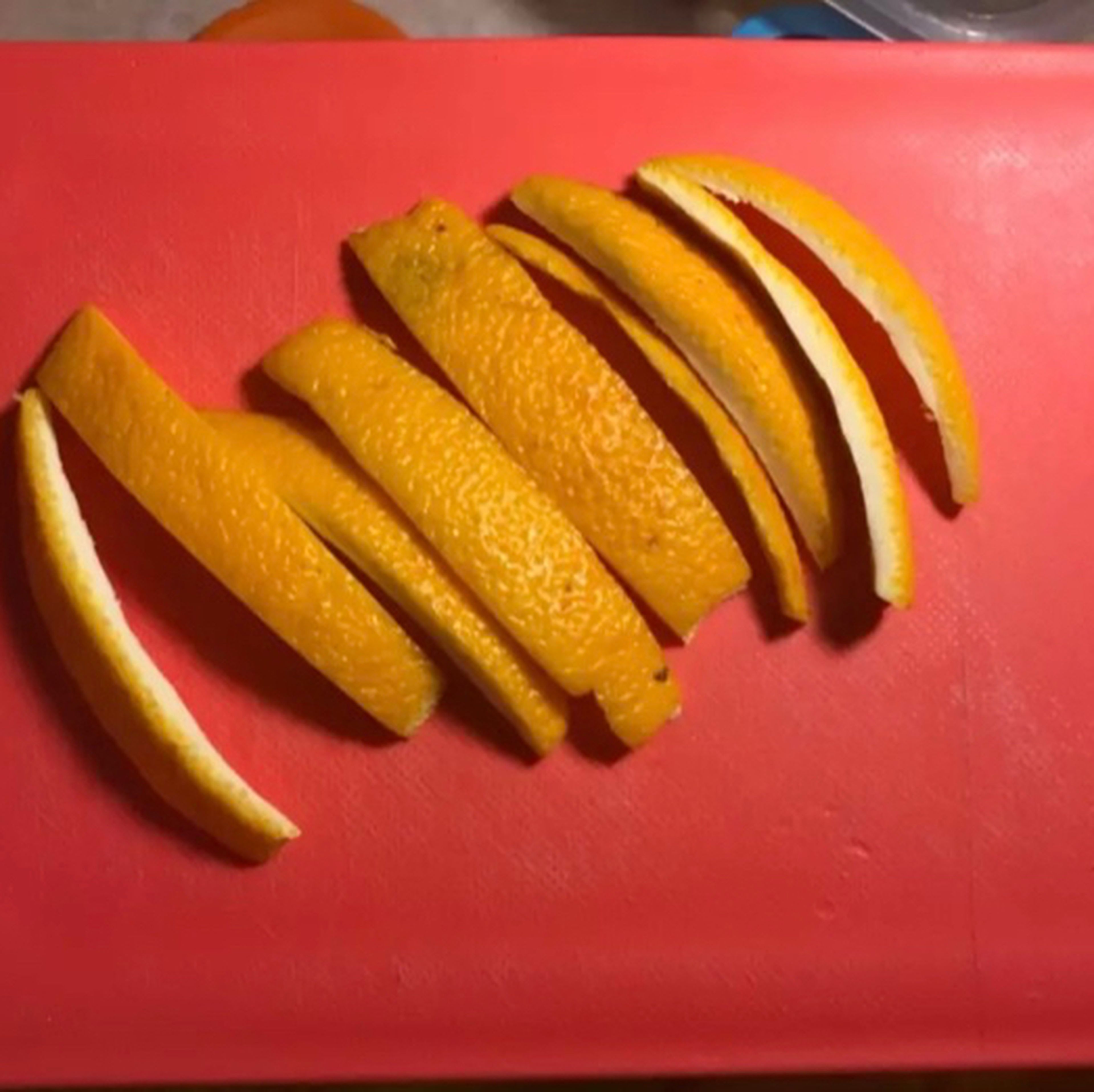 Orange peel should be thick so that it is not curved. Take a little of their white layer with a knife and cut it in the same shape.