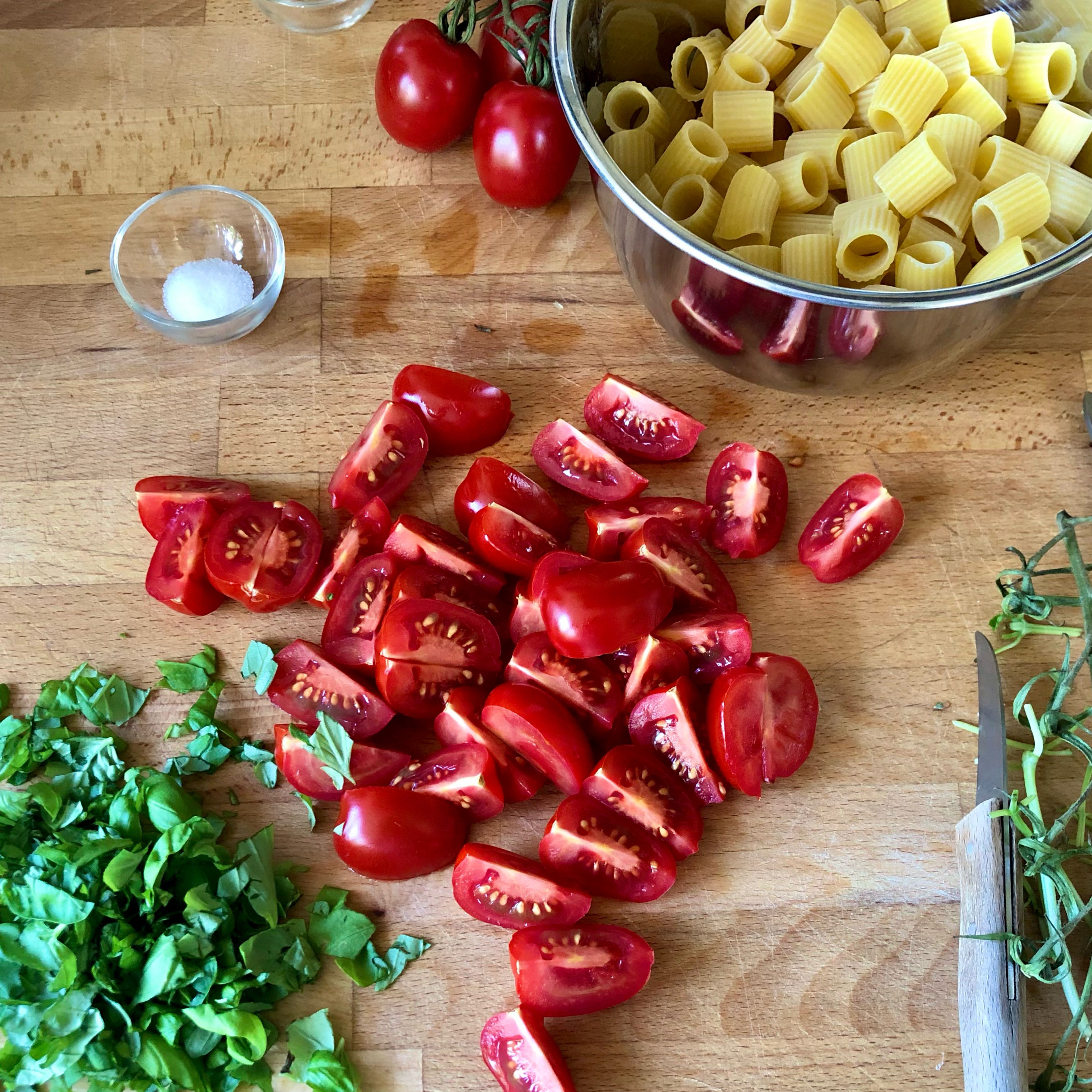 Tomaten in mundgerechte Stücke schneiden, Basilikum grob hacken. Nudeln portionieren, etwa 180 Gramm für 2 Portionen. Die auf der Packung angegebene Kochzeit verifizieren.