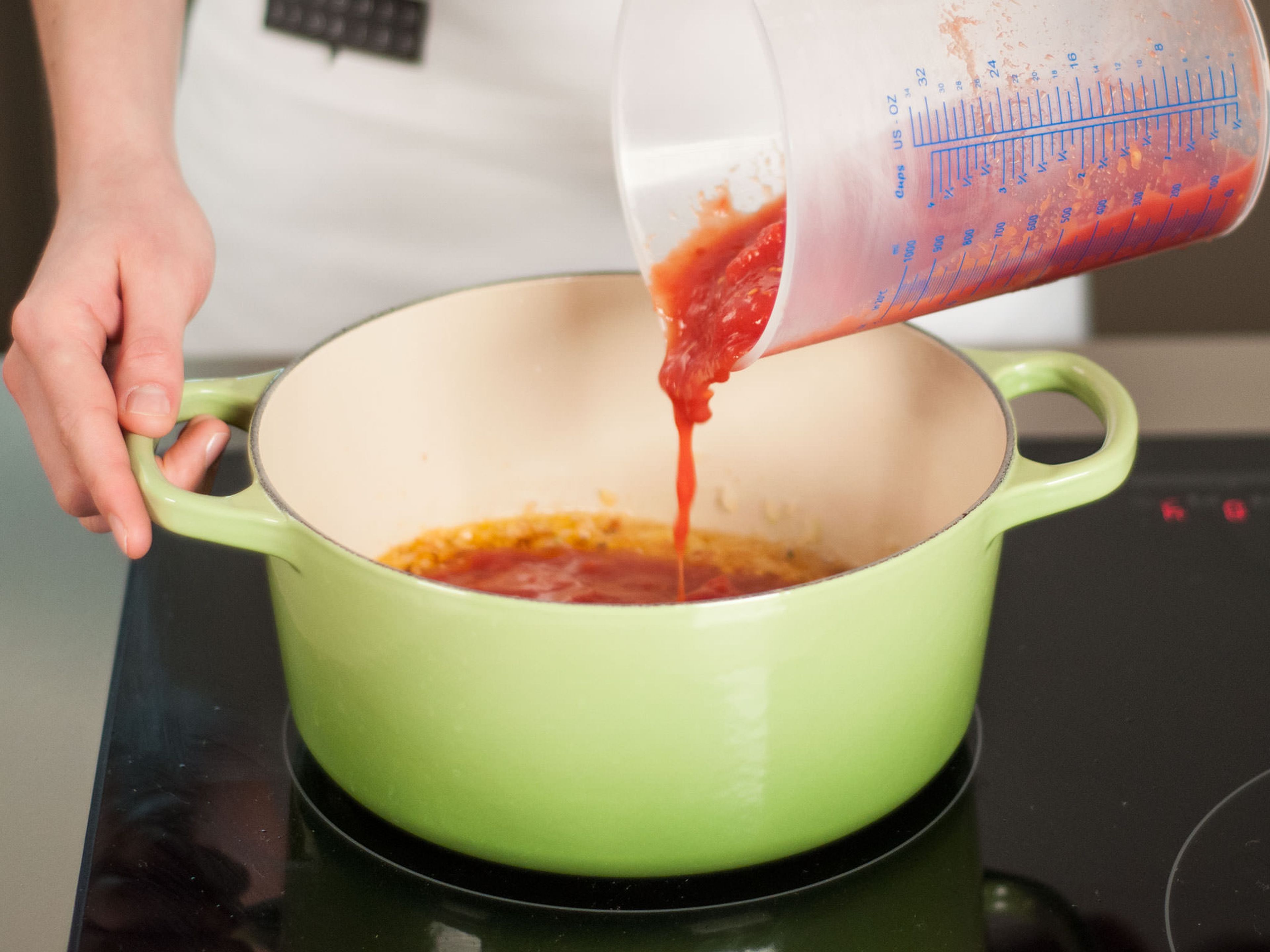 Tomaten in den Topf geben und zum Kochen bringen.