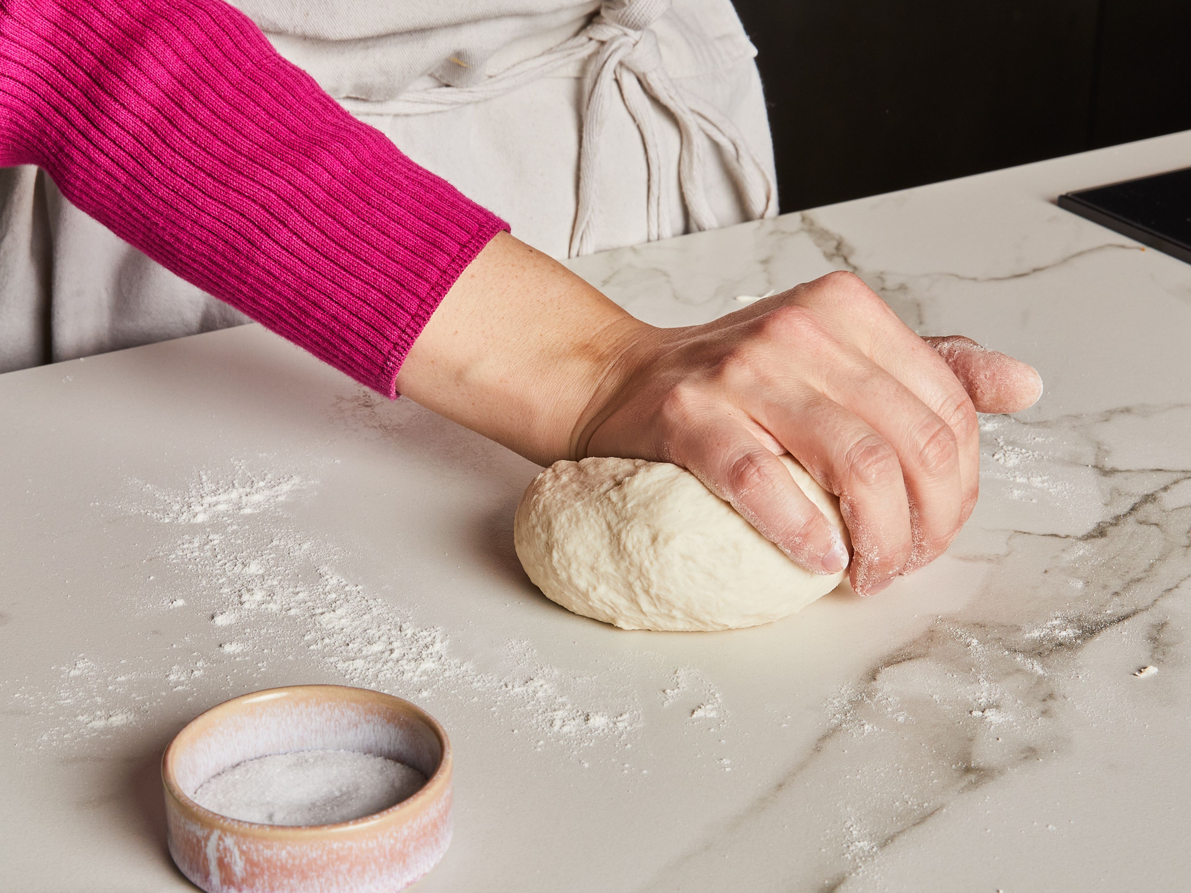 Mehl mit Salz mischen, einen Teil des Wasser hinzugeben und mit einem Holzlöffel verrühren, bis ein krümeliger Teig entsteht. Mit den Händen ca. 2 Min. kneten, bis der Teig geschmeidig ist. Zu einer Kugel formen, mit einem Küchenhandtuch abdecken und für mindestens 20 Min. ruhen lassen.