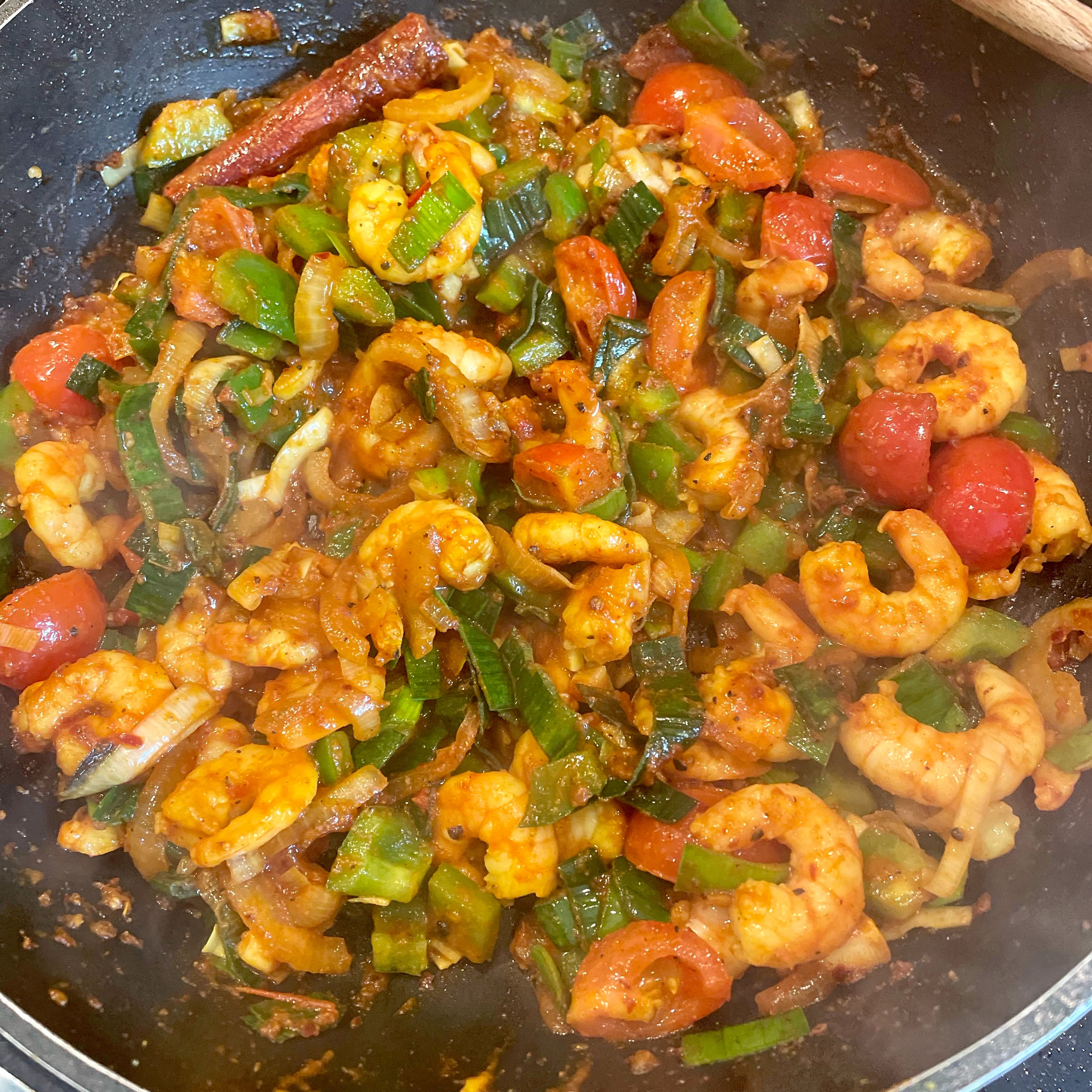 Add sugar, chili paste, soy sauce and tomato sauce. Fry for a minute, then add vegetables. Fry for about five minutes. Finally add prawns, mix and cook for another three minutes.