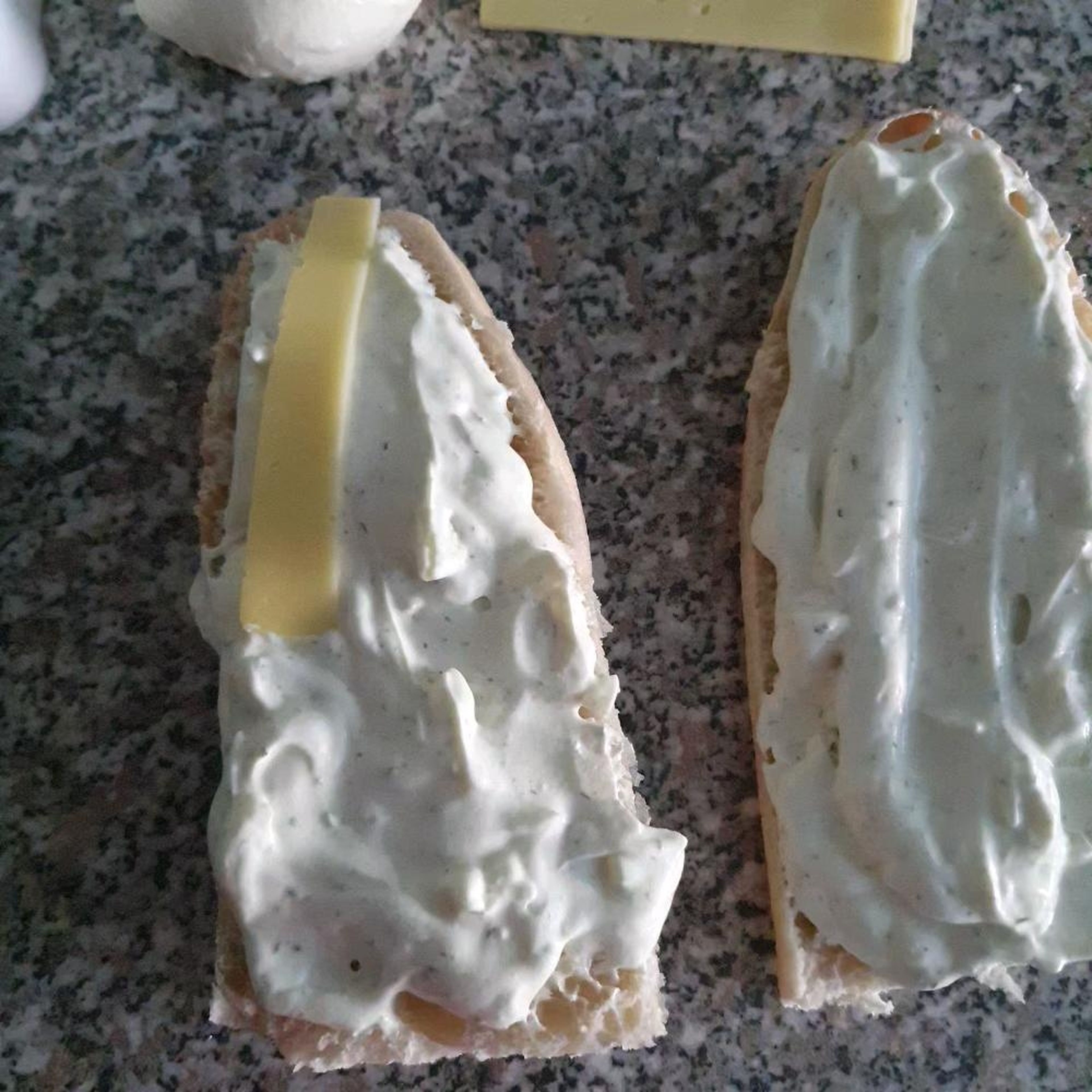 Schritt zwei, Baguette mit der Sauce streichen und mit Butterkäse belegen. Butterkäse hat einen eigenen Geschmack, wenn es gebacken ist.