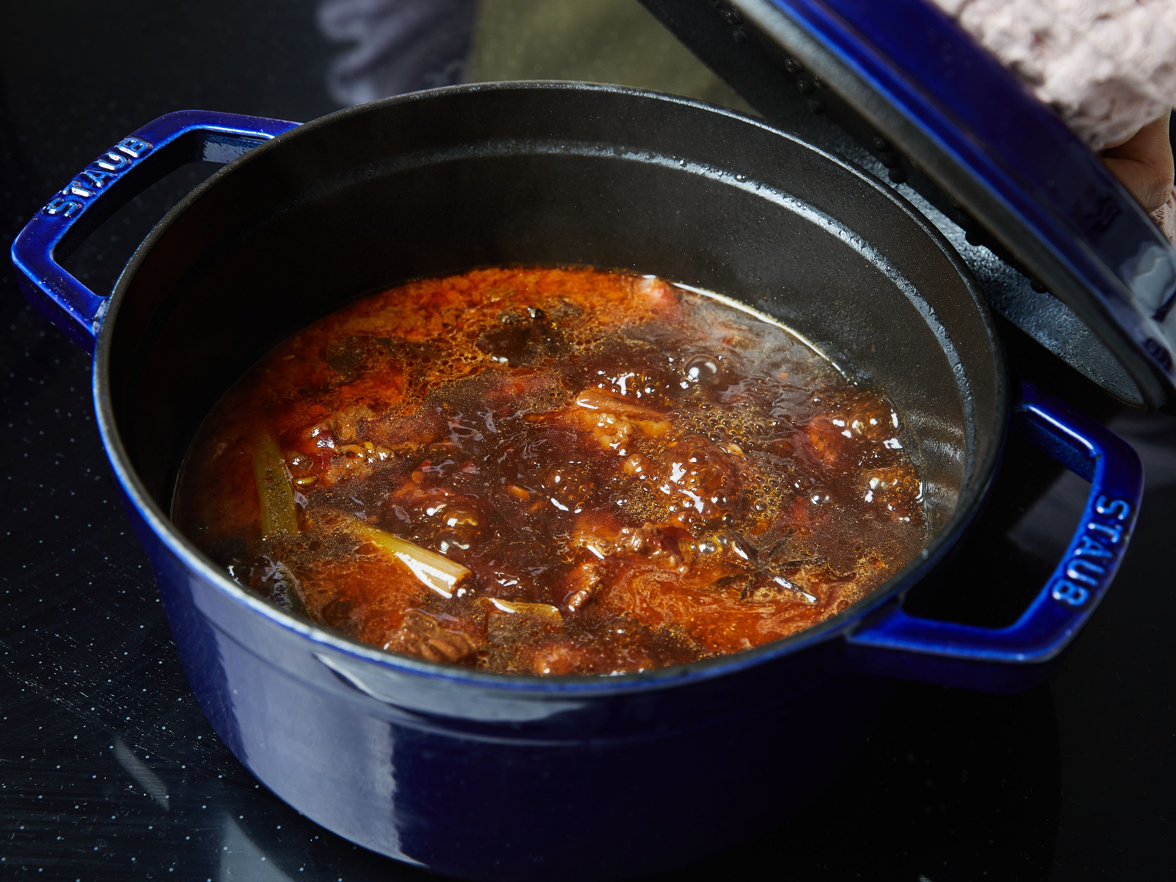 Add the stock and the water to the pot and bring it to a simmer. Cook the beef with the lid on, over medium-low heat, stew for at least 45 min., or until the soup has reduced, and the beef is soft. You can also cook longer for up to 2 hr. for a more tender meat.