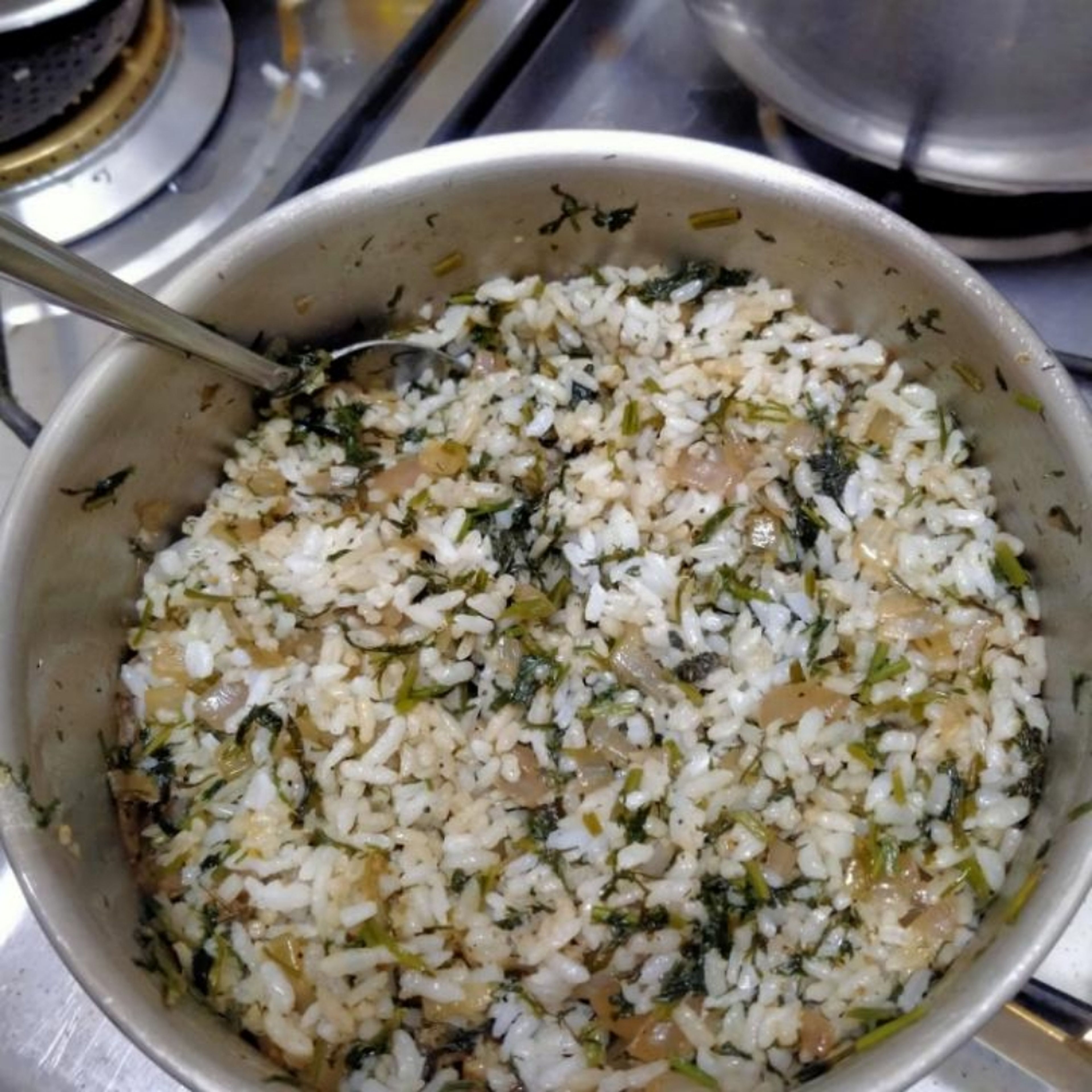 add the rice that we have cooked earlier to the onion and greens mix and mix it very well