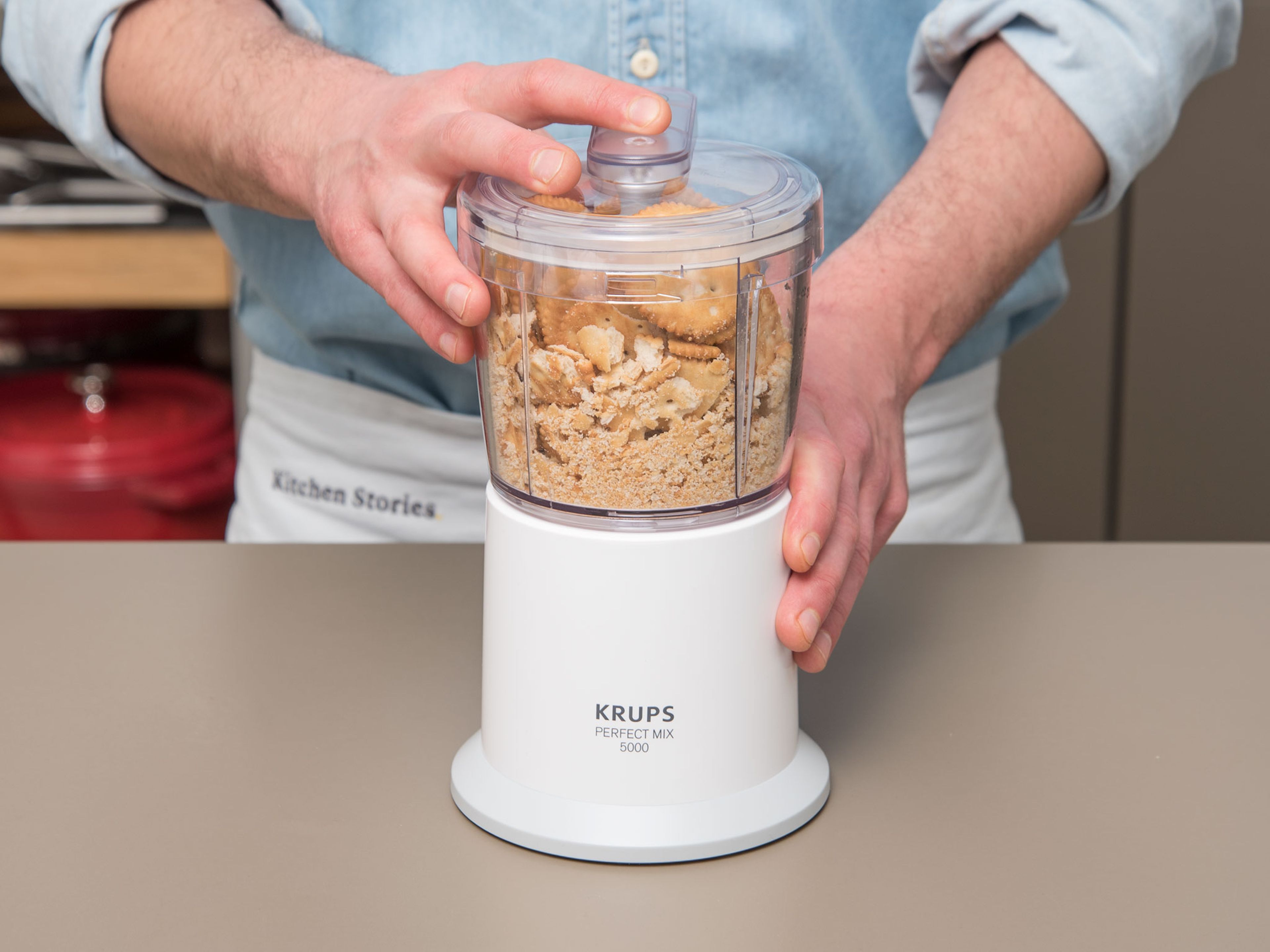 Put the salty crackers in a food processor and finely grind.