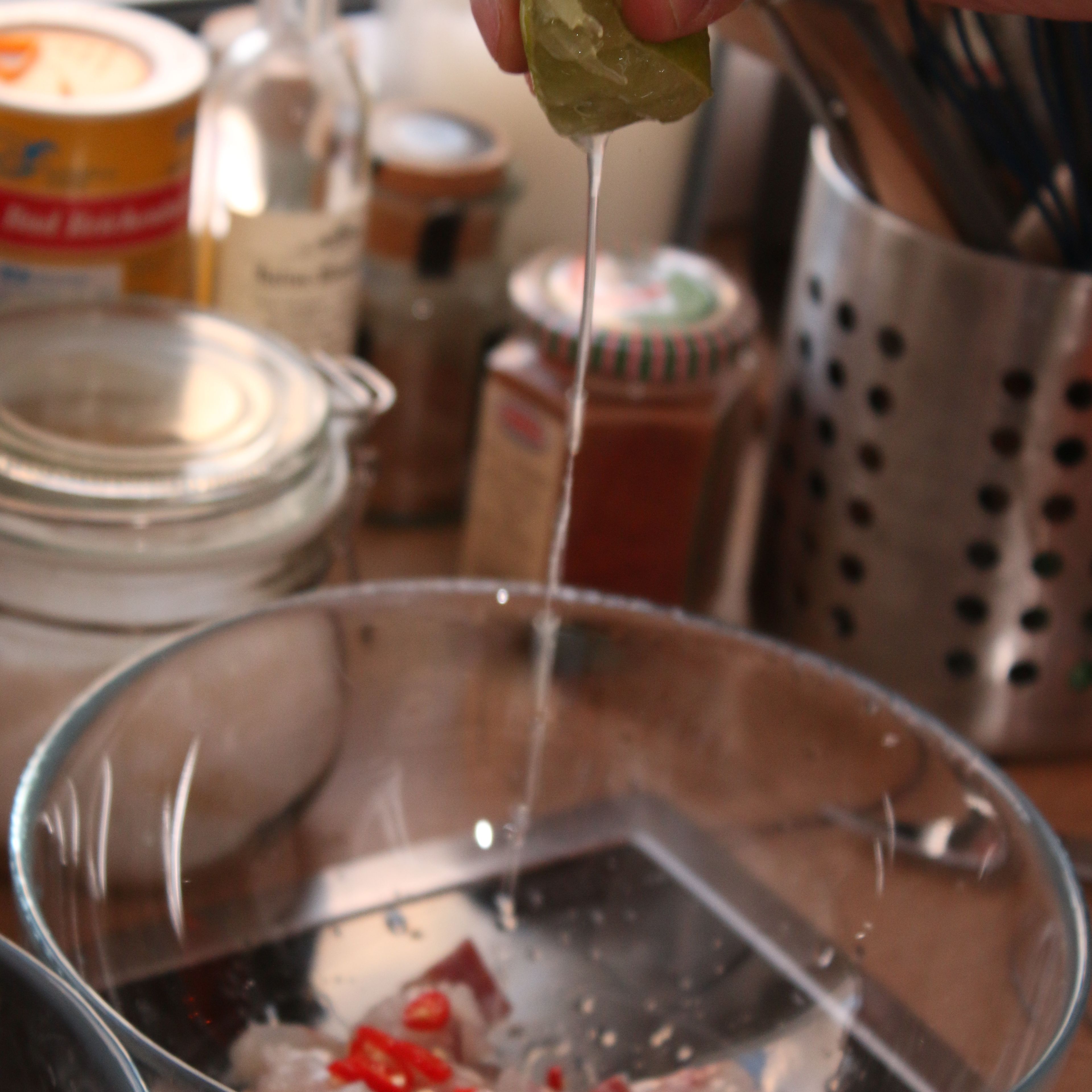 Den gewürfelten Rotbarsch und die Chili in eine große Glasschüssel geben und die Limetten darüber auspressen. Wichtig: Kein Metallgefäß verwenden, da durch die Reaktion mit der Säure ein unangenehmer Geschmack entsteht.