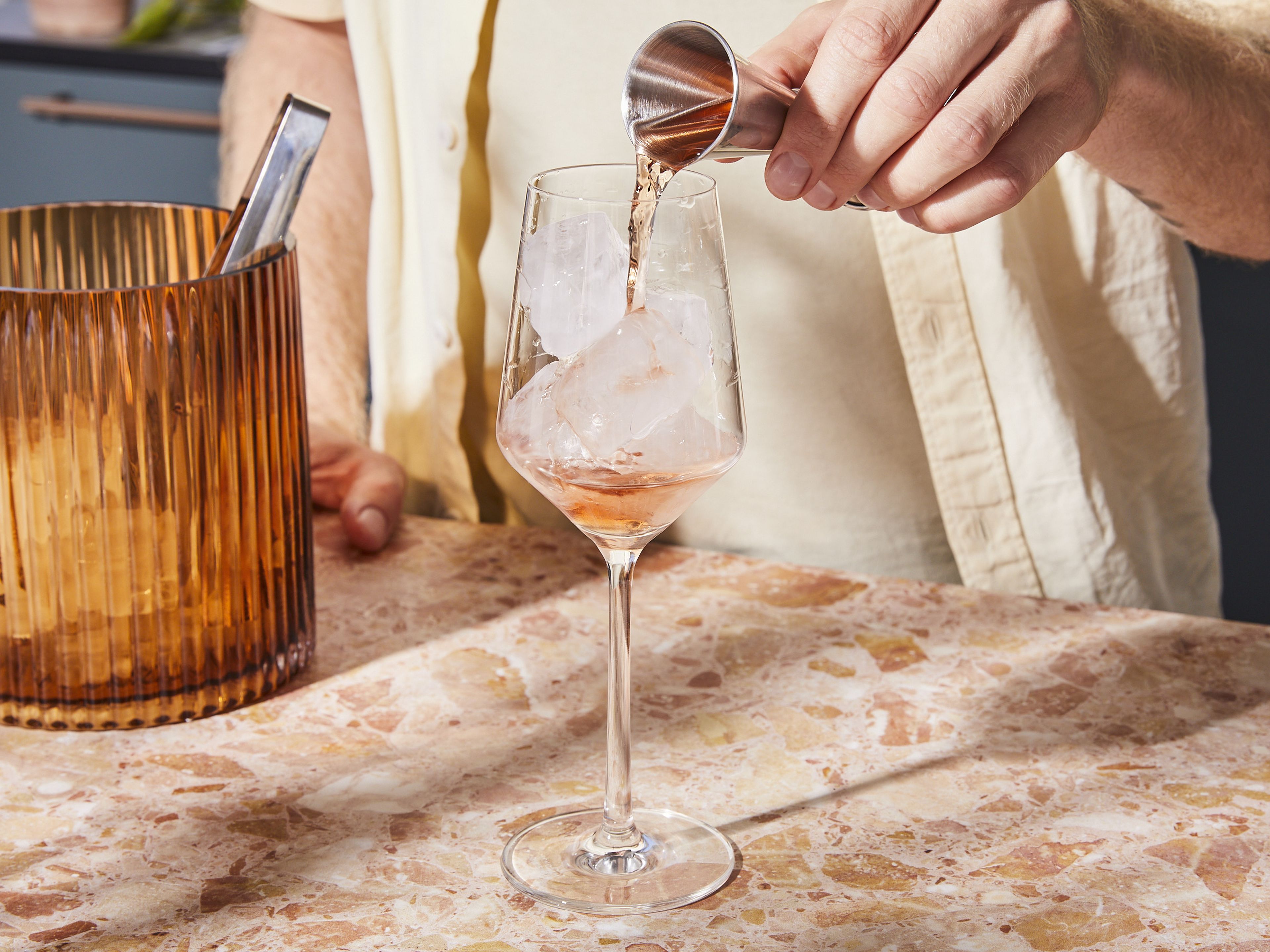 Ein Glas mit Eiswürfeln füllen und den Wein-Aperitif hineingeben.