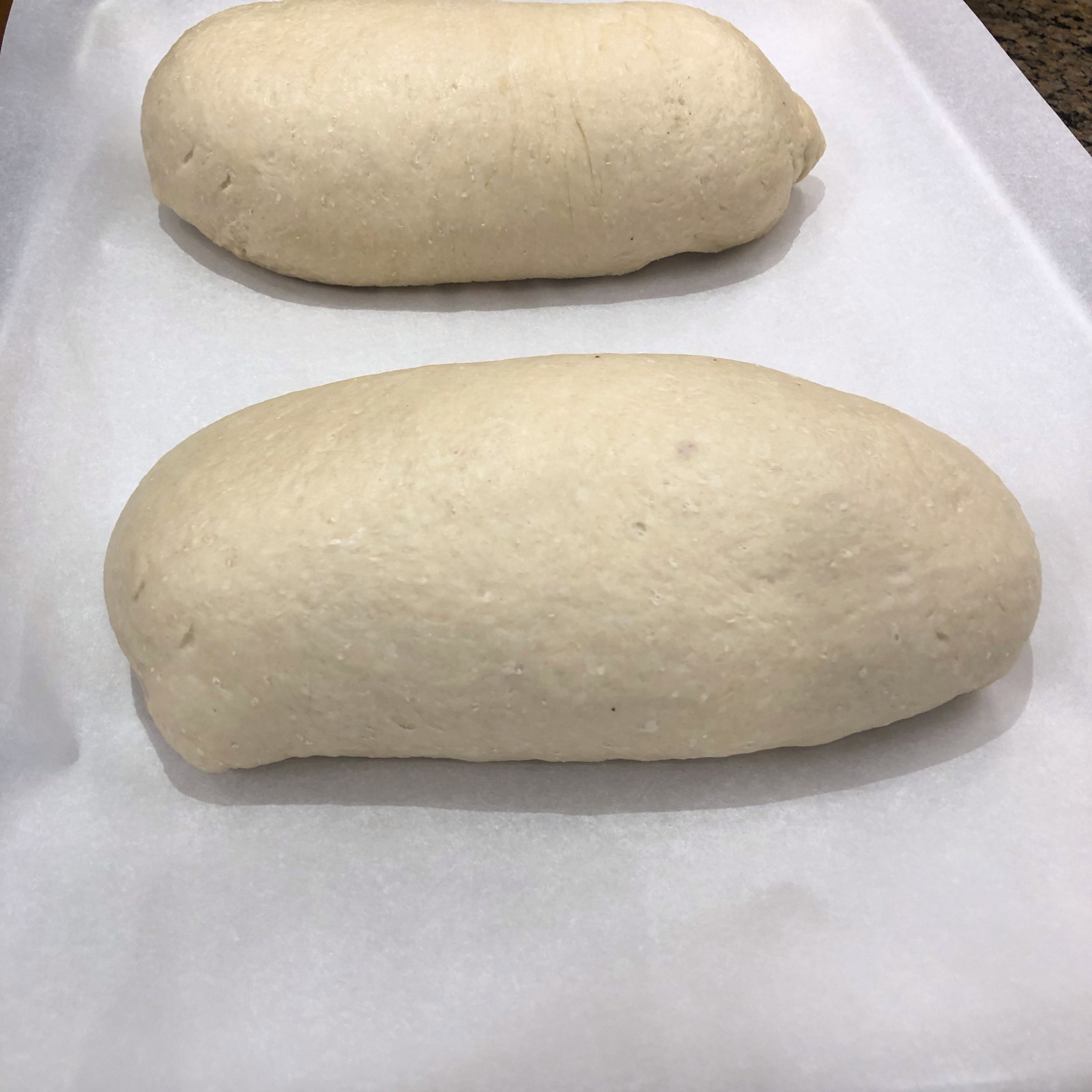 Line a large baking tray with parchment paper. Place loaves, seam side down, on the tray, leaving enough space between them for expansion as they rise. Cover with kitchen towel and set tray in a warm spot and allow bread to rise for 30 - 40 minutes.