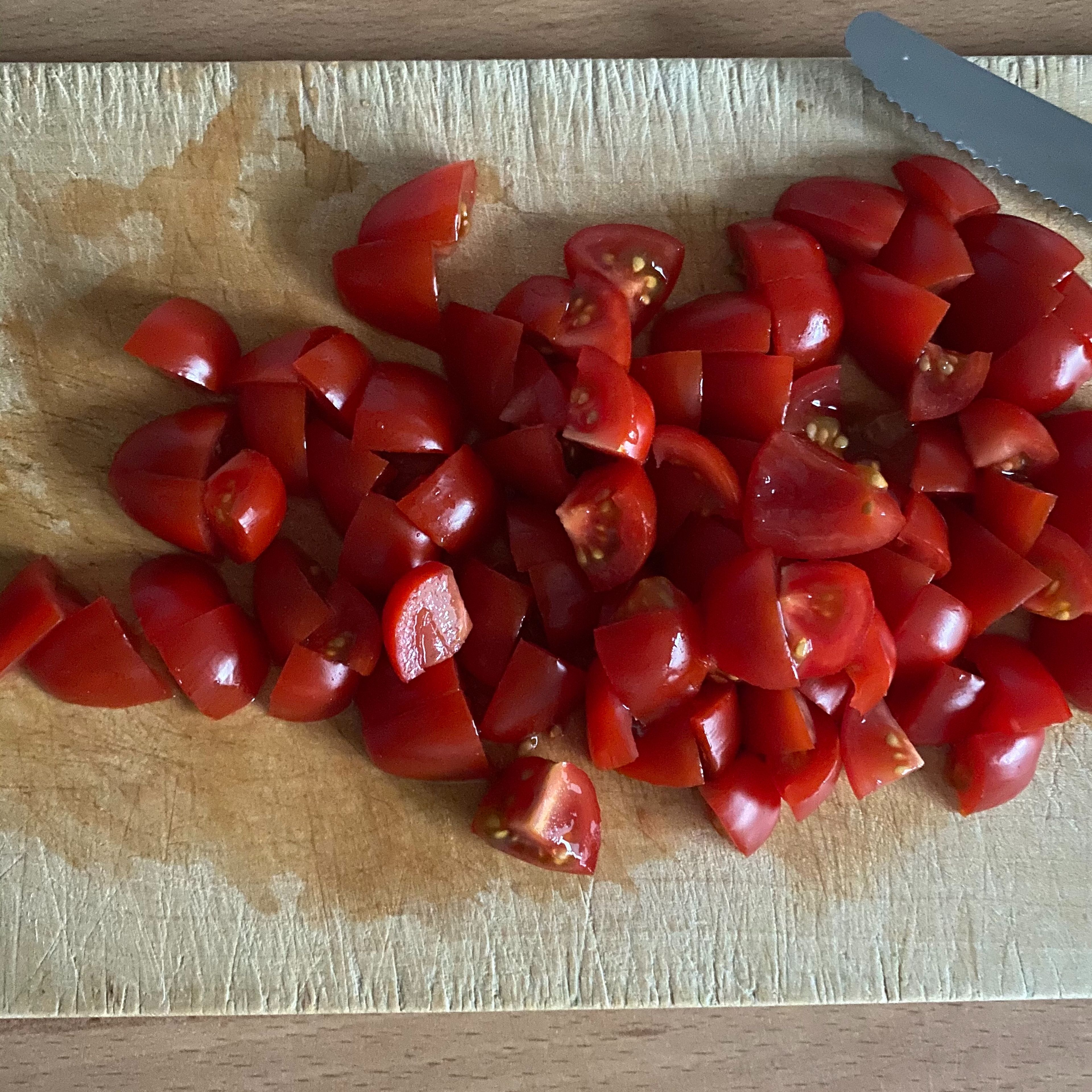 Die Tomaten in ca. 1cm große Würfel schneiden und die Oliven in Ringe schneiden.