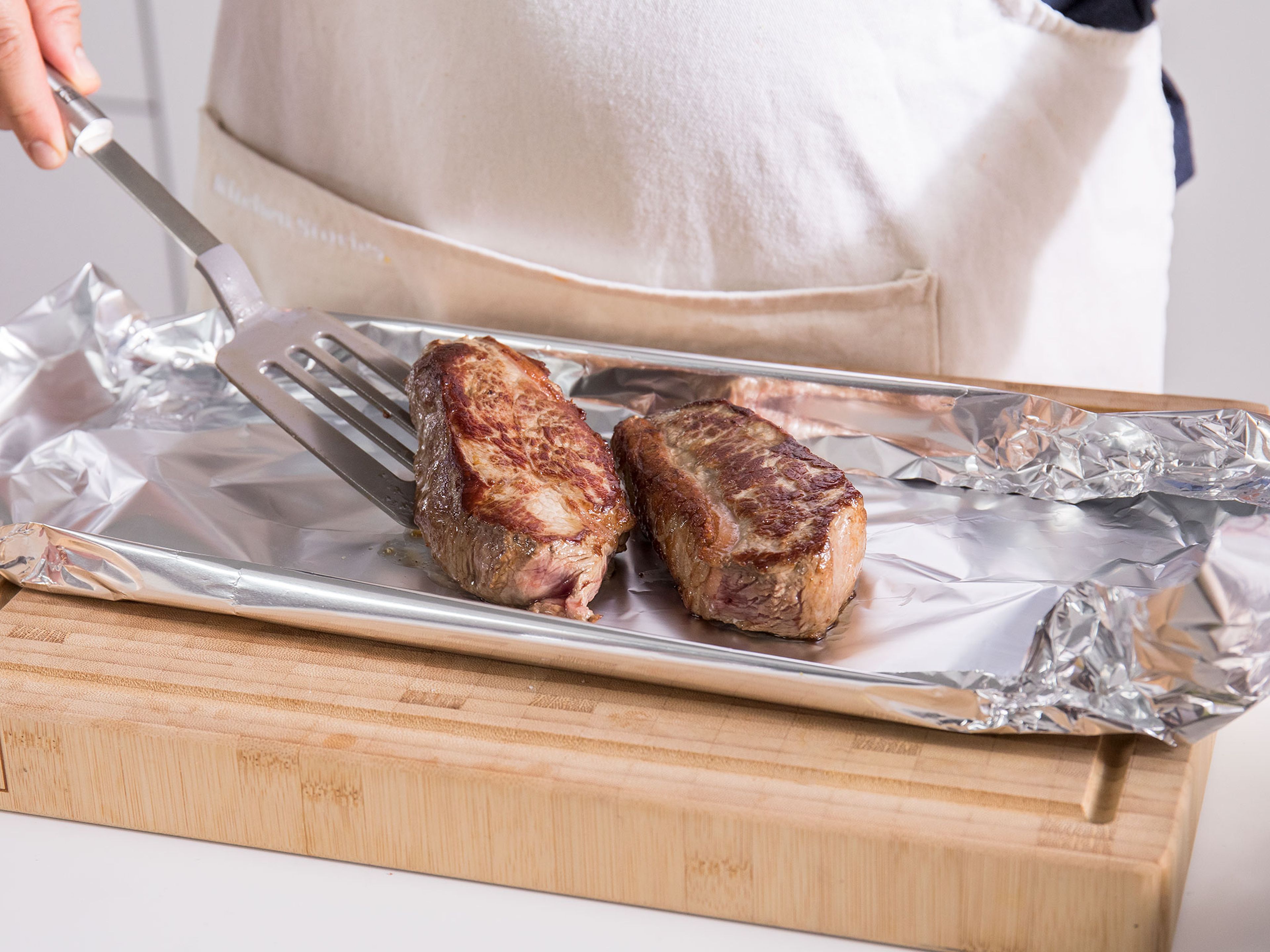 Für das Fleisch, den Fettrand der Steaks in regelmäßigen Abständen einschneiden. Eine Pfanne bei mittlerer bis hoher Temperatur erhitzen. Das Fleisch salzen und scharf anbraten. Mit Pfeffer würzen und jedes Steak in Aluminiumfolie einpacken. Für ca. 3 Min. ruhen lassen. Die Sauce mit Butter abbinden und mit Salz und Pfeffer würzen. Steaks mit Zwiebelsauce und Kartoffeln servieren. Guten Appetit!