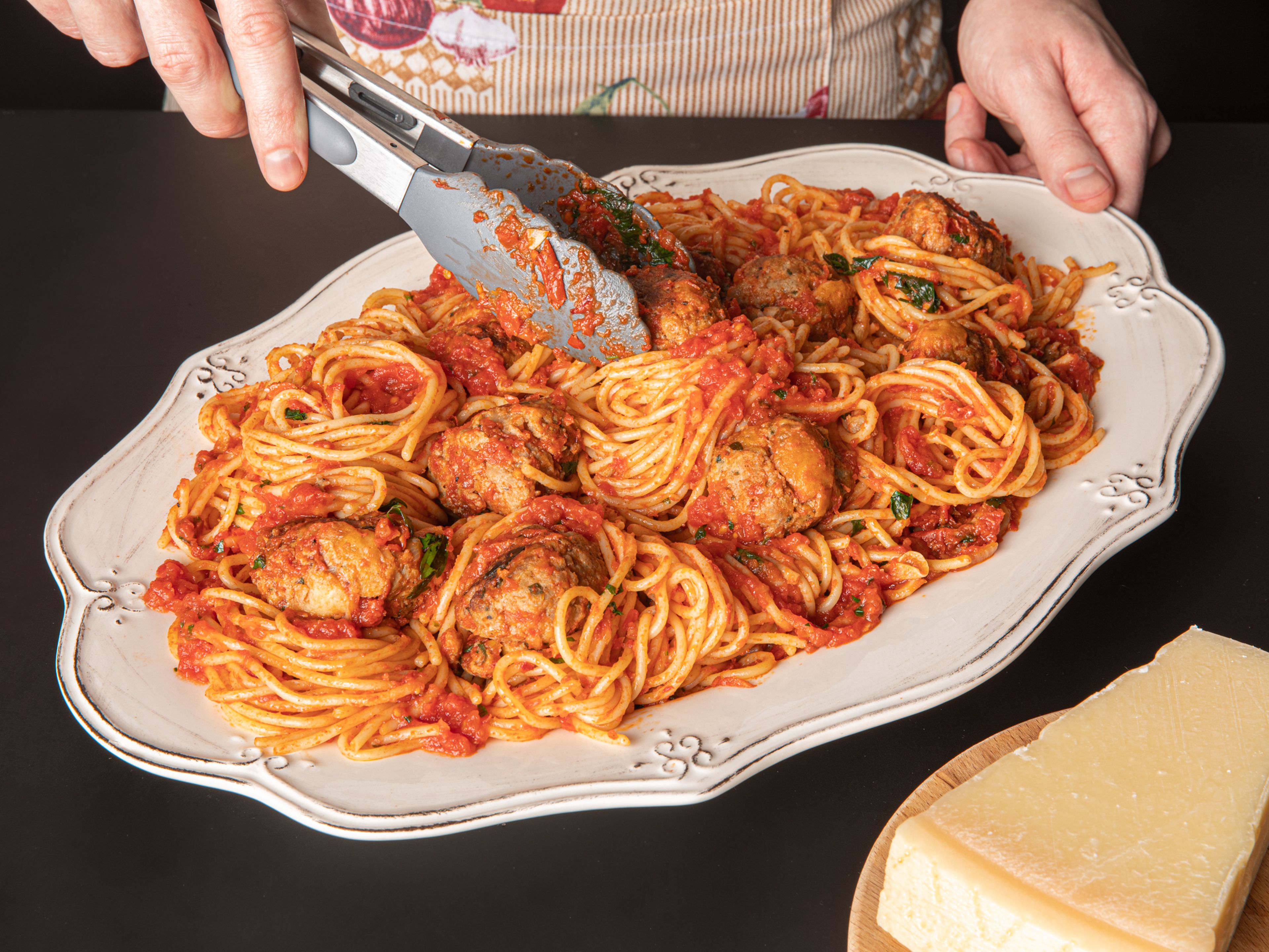 Spaghetti in kochendes Salzwasser geben und bissfest kochen. Etwa nach der Hälfte der Kochzeit eine große Kelle Nudelwasser in die Tomatensoße geben. Die Soße abschmecken. Dann die Fleischbällchen hinzufügen, vorsichtig umrühren und noch kurz köcheln lassen, bis sie durchgewärmt sind. Spaghetti abgießen und zusammen mit etwas Petersilie in die Soße geben, alles vorsichtig umrühren. Servieren und mit Petersilie garnieren. Guten Appetit!