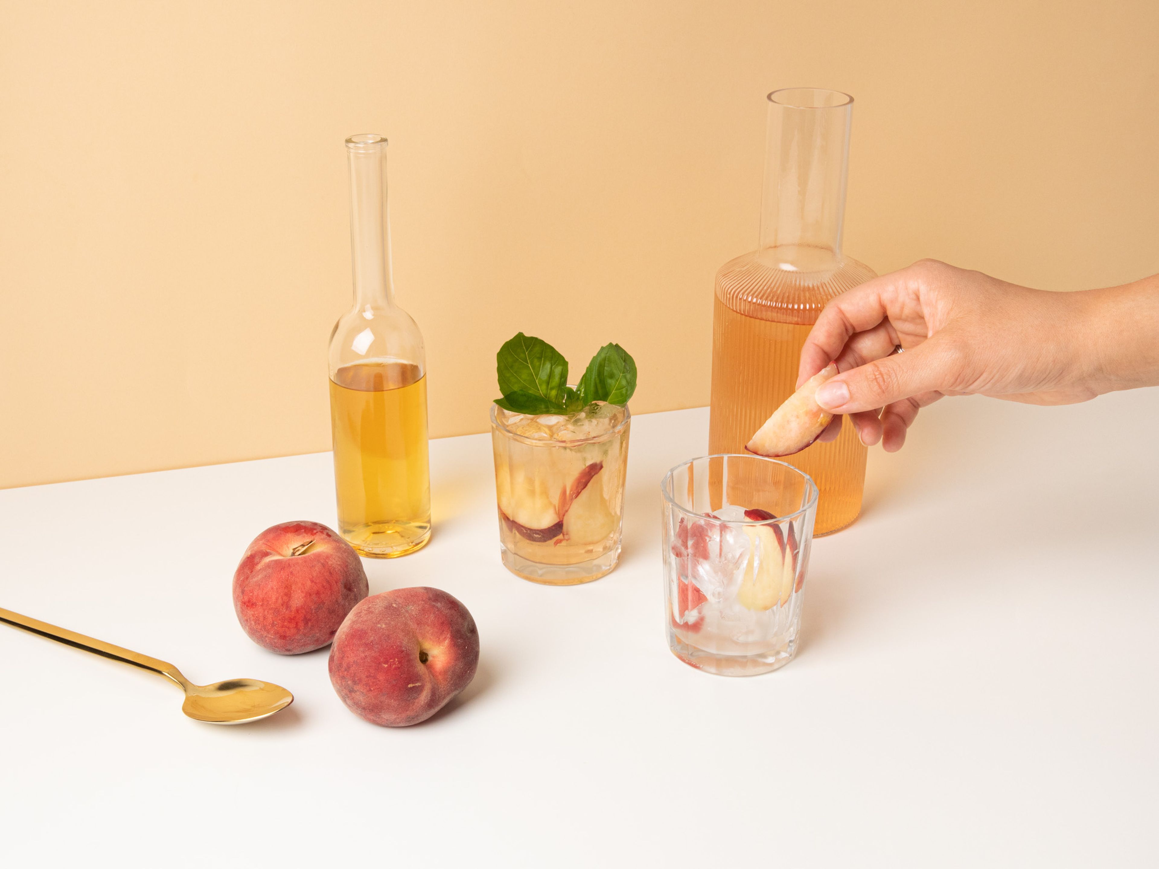 Cut peaches into pieces. Add ice to glasses, divide peaches among the glasses, and top up with the rosé spritzer. Stir to combine and garnish generously with basil. Enjoy!