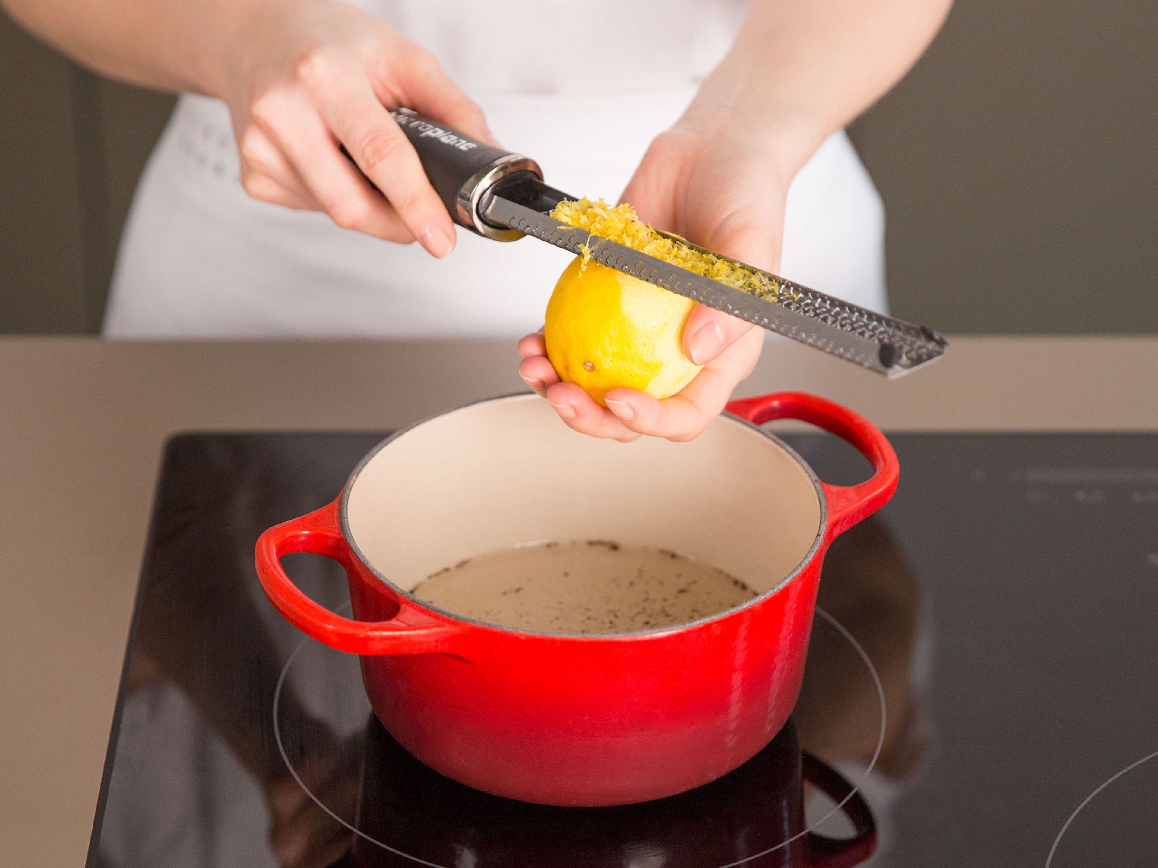 In einem kleinen Topf Zucker mit Wasser, dem Mark einer Vanilleschote und dem Abrieb einer Zitrone aufkochen.