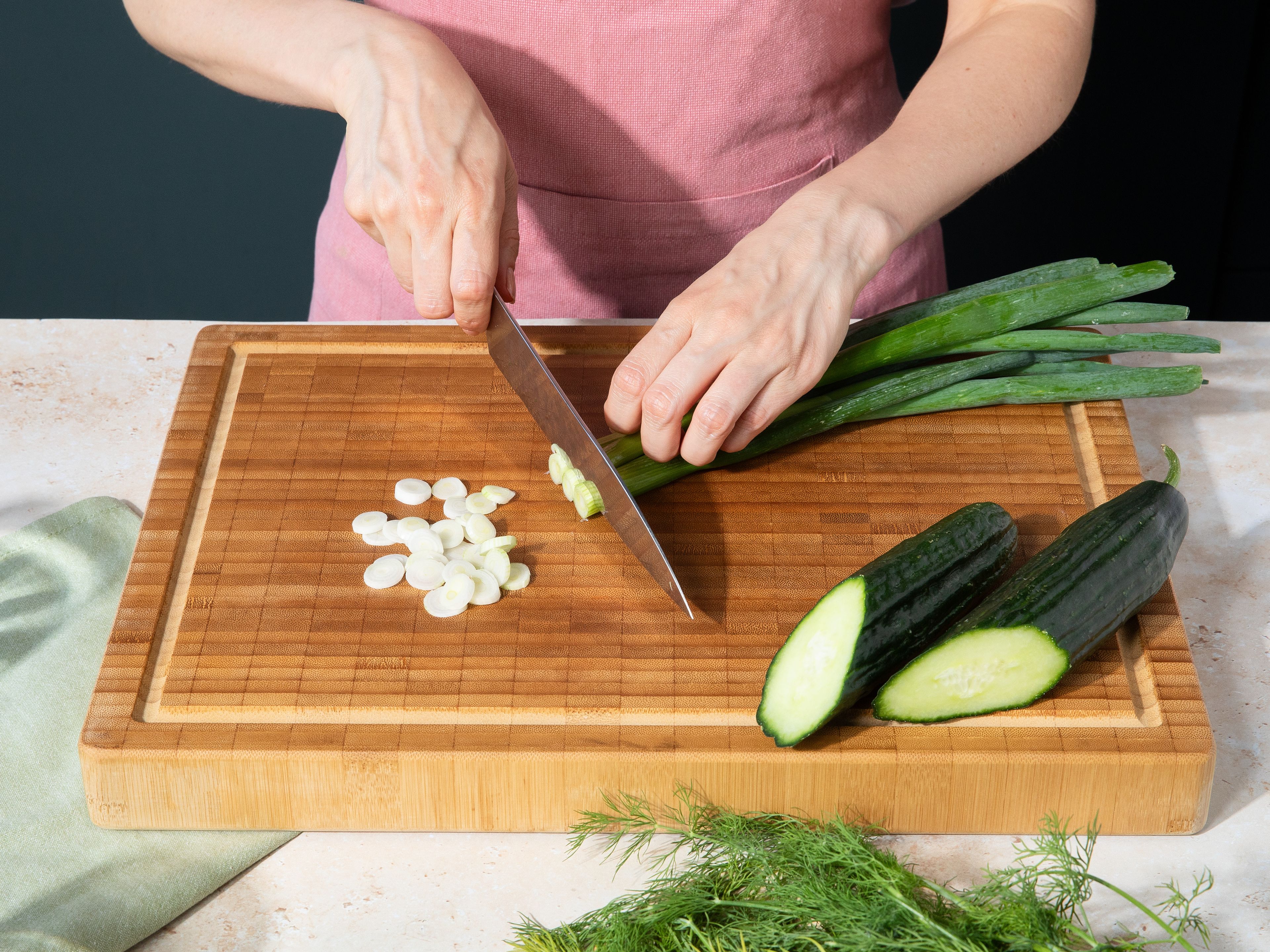 Die Frühlingszwiebeln in feine Ringe schneiden und den Dill fein hacken und jeweils etwas zum Garnieren beiseitelegen. Die Gurke grob raspeln oder fein würfeln. Alles zusammen mit der Roten Beete in eine große Schüssel oder Topf geben.