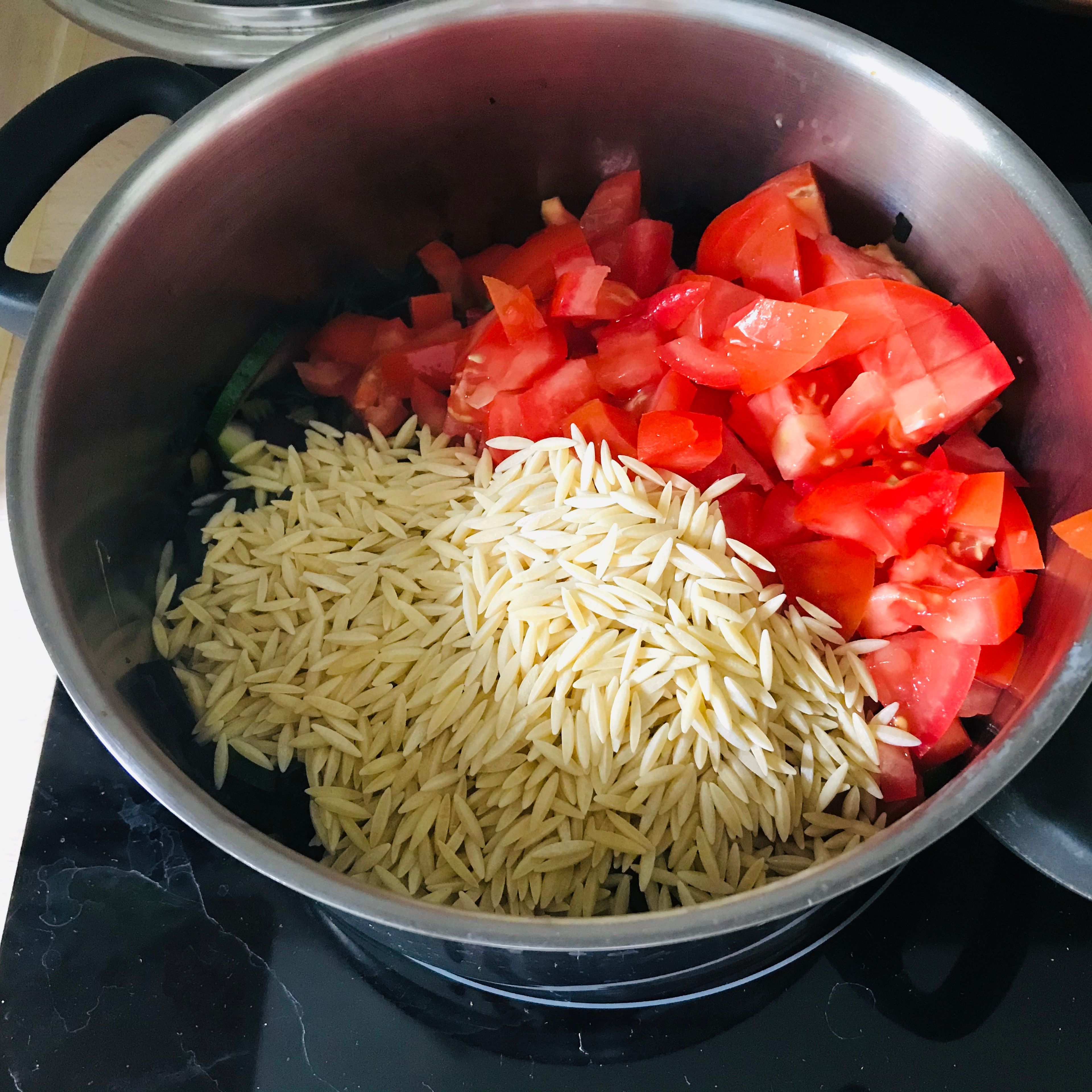 Tomaten, Nudeln und Gemüsebrühe zu dem Gemüse geben und für 15 Minuten kochen lassen. Zwischendurch umrühren und bei Bedarf noch etwas Gemüsebrühe hinzugeben.