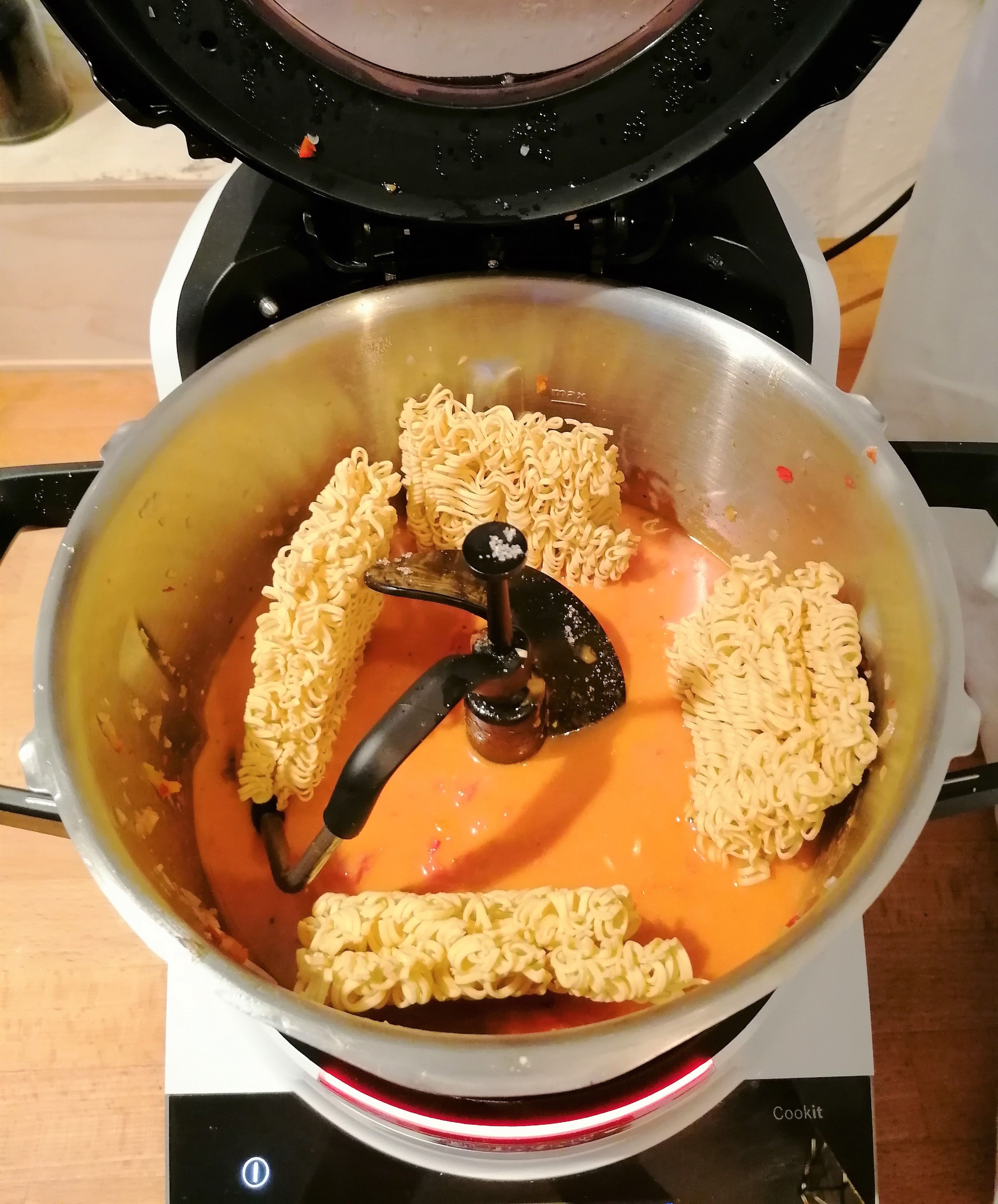 Den 3D-Rührer einsetzen. Das Kokosöl und die Currypaste dazugeben, Deckel schließen, Messbecher entfernen und das Gemüse im Cookit anschwitzen (3D-Rührer | Stufe 4 | 120°C | 4 Min.). Die Tomaten, Chiliflocken, Salz, Rohrzucker, Saft einer Limette, Limettenabrieb und die Kokosmilch dazugeben, den Deckel ohne Messbecher schließen und erhitzen und köcheln lassen (3D-Rührer | Stufe 4 | 95°C | 15 Min.). Die Mie-Nudeln dazugeben und weiter bei geschlossenem Deckel, ohne Messbecher, köcheln lassen (3D-Rührer | Stufe 4 | 95°C | 2 Min.). Anschließend die Garnelen dazugeben und weiter bei geschlossenem Deckel, ohne Messbecher, köcheln lassen (3D-Rührer | Stufe 4 | 95°C | 6 Min.).