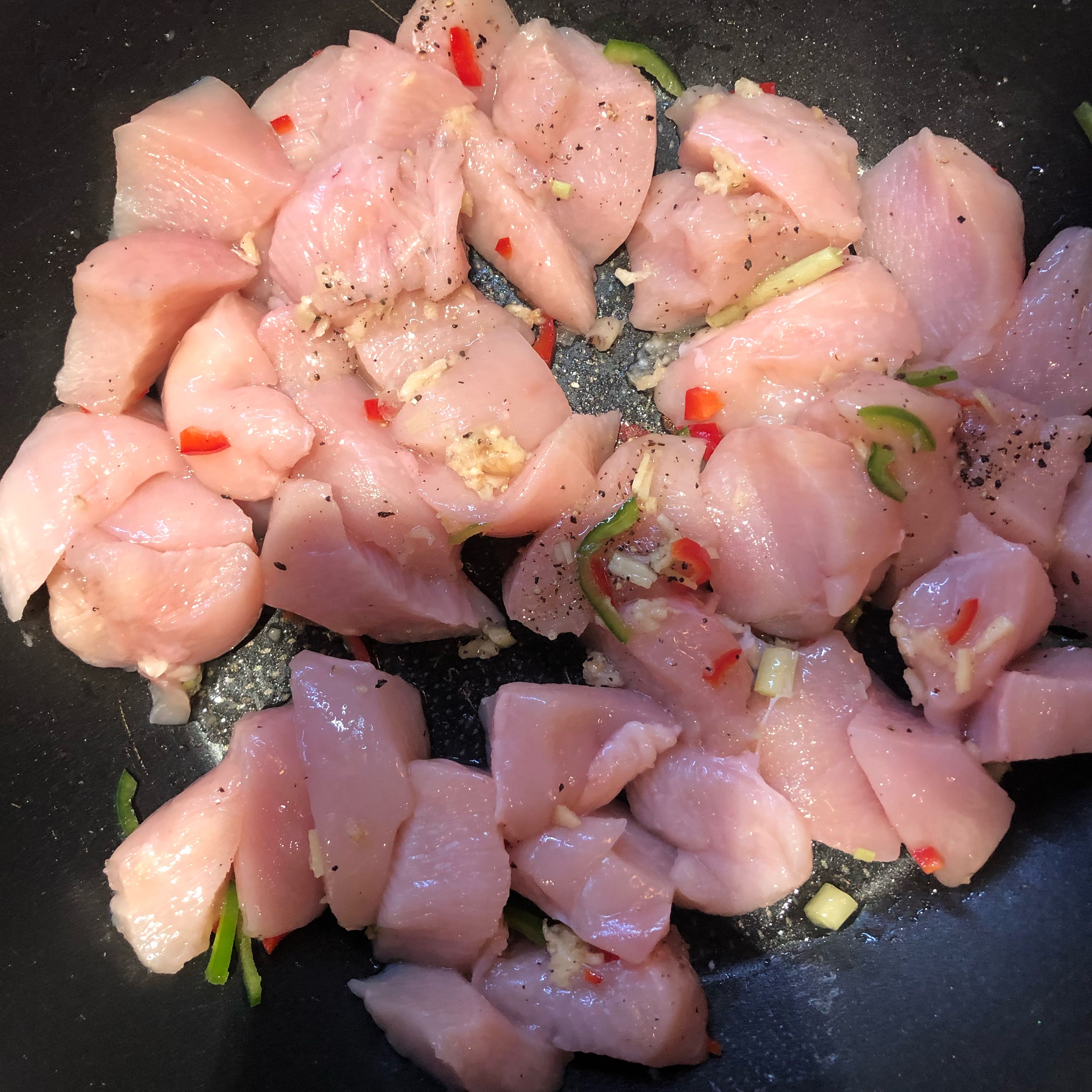 Add crushed garlic, 1 finely sliced chilli, ginger and lemongrass to a pan with oil, salt and pepper. Then add chicken and fry on a medium heat for 8 minutes.