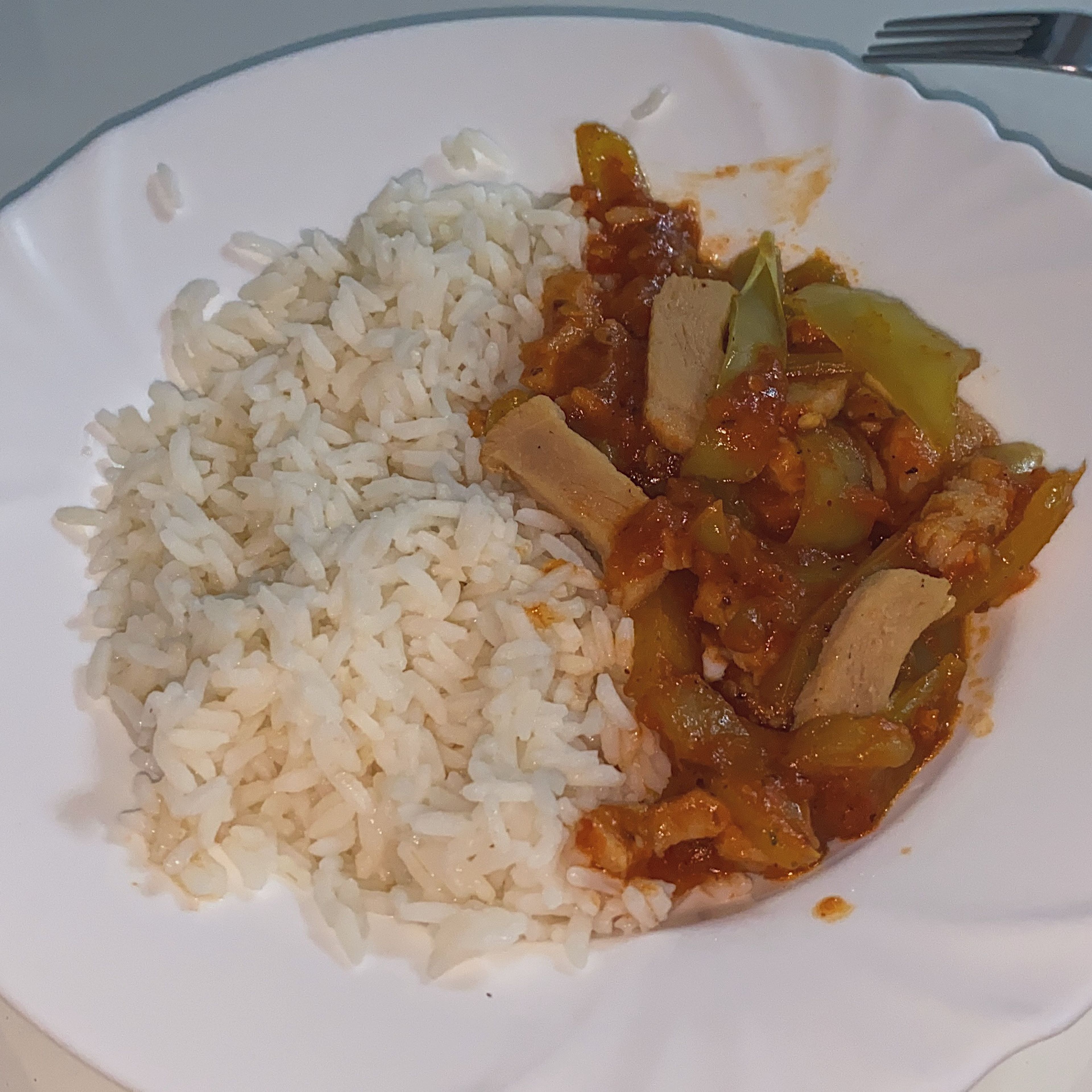 Chicken and pepper with tomato sauce over rice