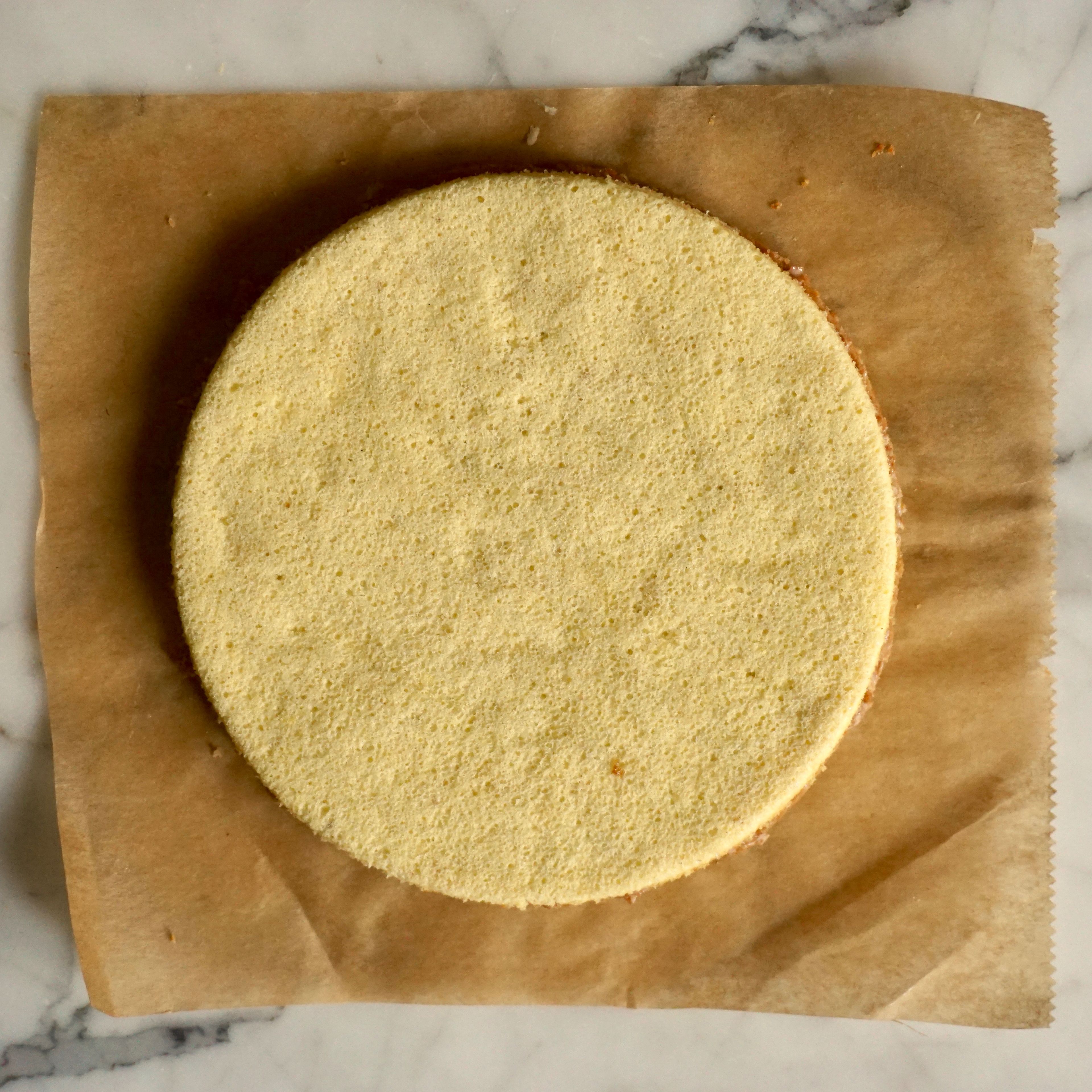 Backofen auf 200°C hochheizen. In einer Schüssel Eiweiß mit Salz und Zucker aufschlagen. Eigelb langsam unterlaufen lassen. Mehl mit den gemahlenen Mandeln vermischen und vorsichtig unter die aufgeschlagene Eimasse heben. Die Biskuitmasse auf ein Backpapier geben und mit einer Winkelpalette ca. 1cm dick verstreichen, auf ein Backblech ziehen und für 10 Minuten backen. Nach dem Backen den Biskuit abkühlen lassen. Zwei Kreis mit ca. 14cm Durchmesser ausstechen.