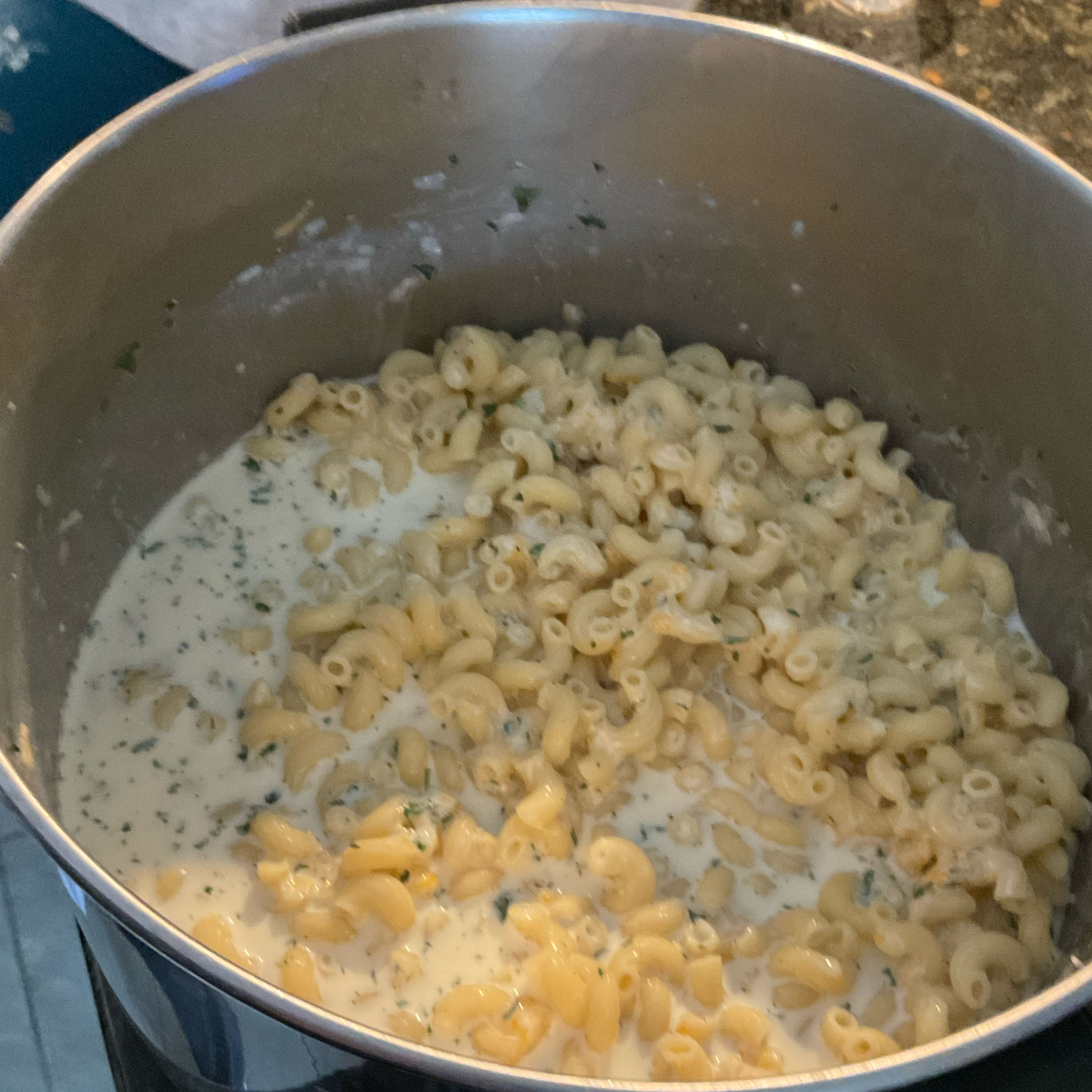 Place strained macaroni ￼into large bowl. Mix in cream, milk, flour, parsley leaves, salt, three quarters of the cheese mix, and pepper into the bowl and stir.￼