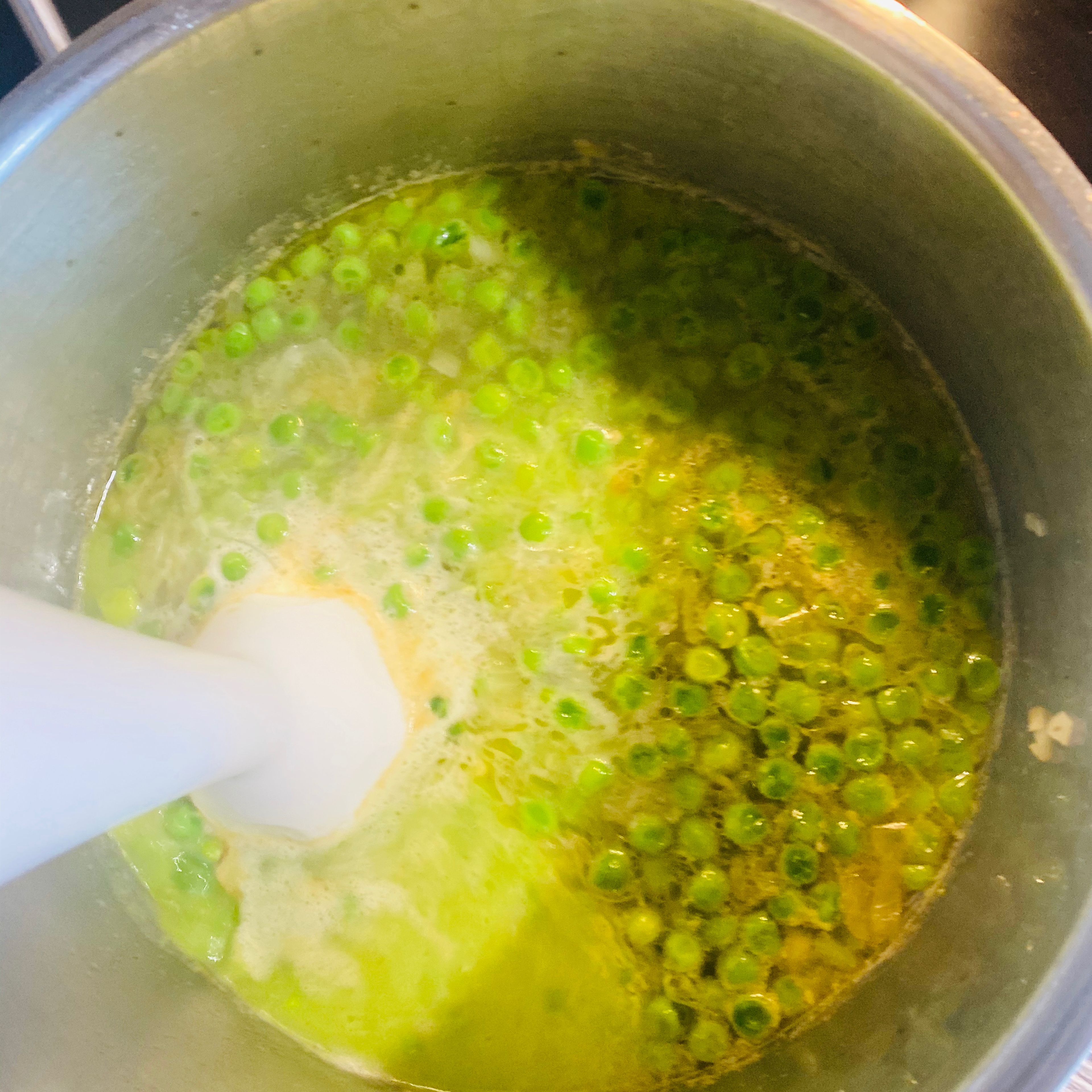Die Suppe vom Kochfeld nehmen. Mit dem Mixstab die Erbsensuppe gut durch mixen, bis kaum noch Stücke zu sehen sind.
